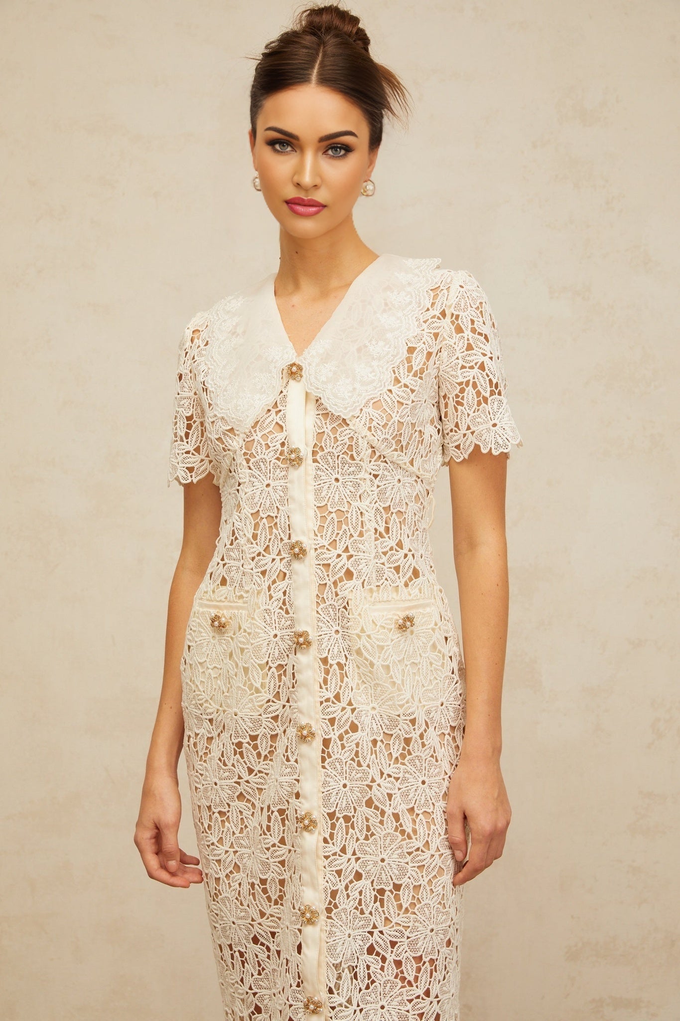 A white lace midi dress with offshoulder design and intricate corded lace pattern