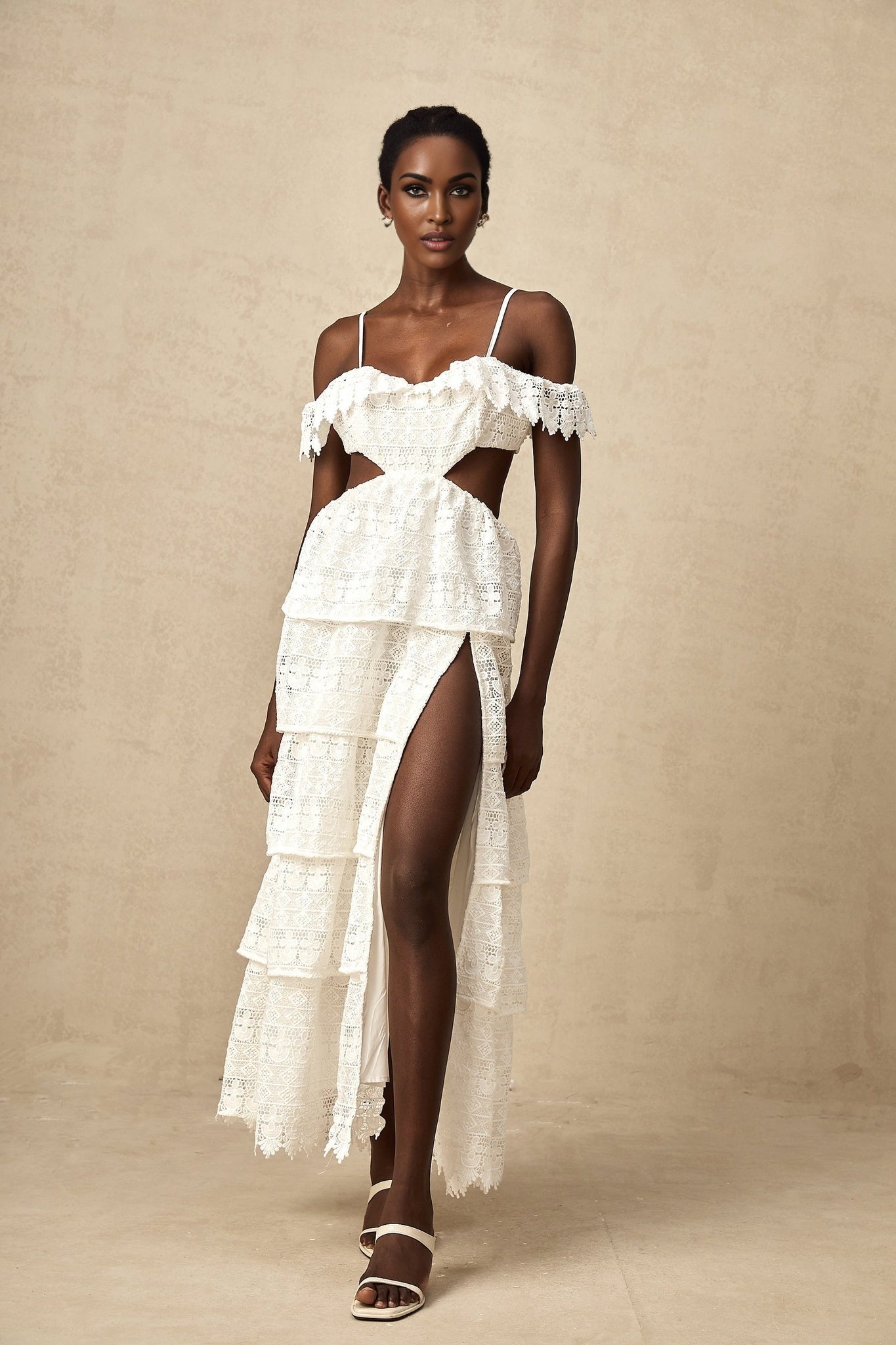 A white lace midi dress with open work detailing named Genevieve displayed on a plain background