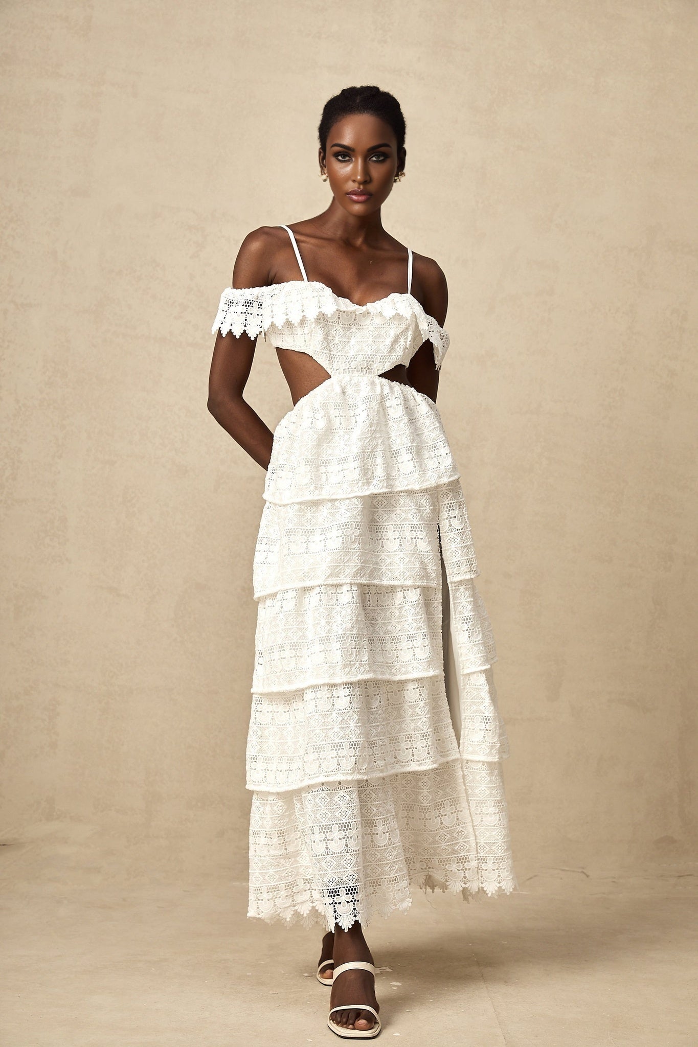 A white lace midi dress with open work detailing named Genevieve featuring a delicate pattern and feminine silhouette