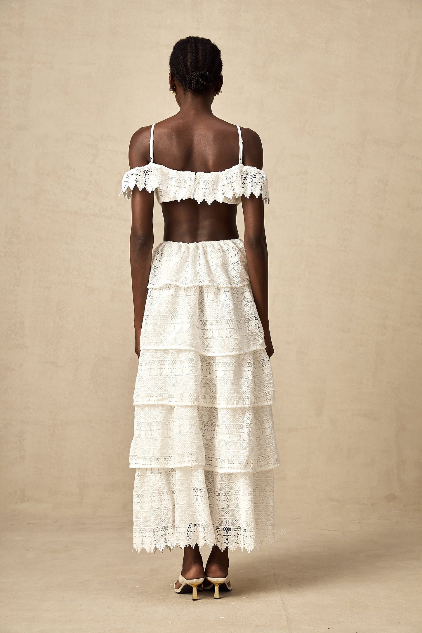 A white lace midi dress with openwork detailing named Genevieve featuring a delicate floral pattern and a feminine silhouette