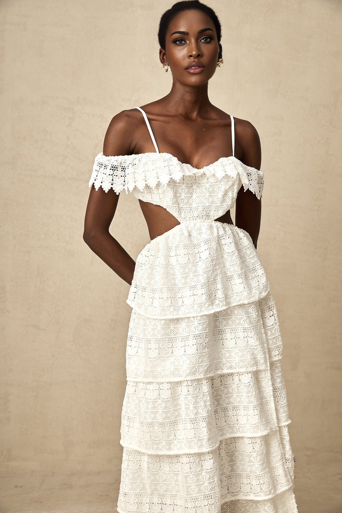 A white lace midi dress with openwork details named Genevieve on a plain background