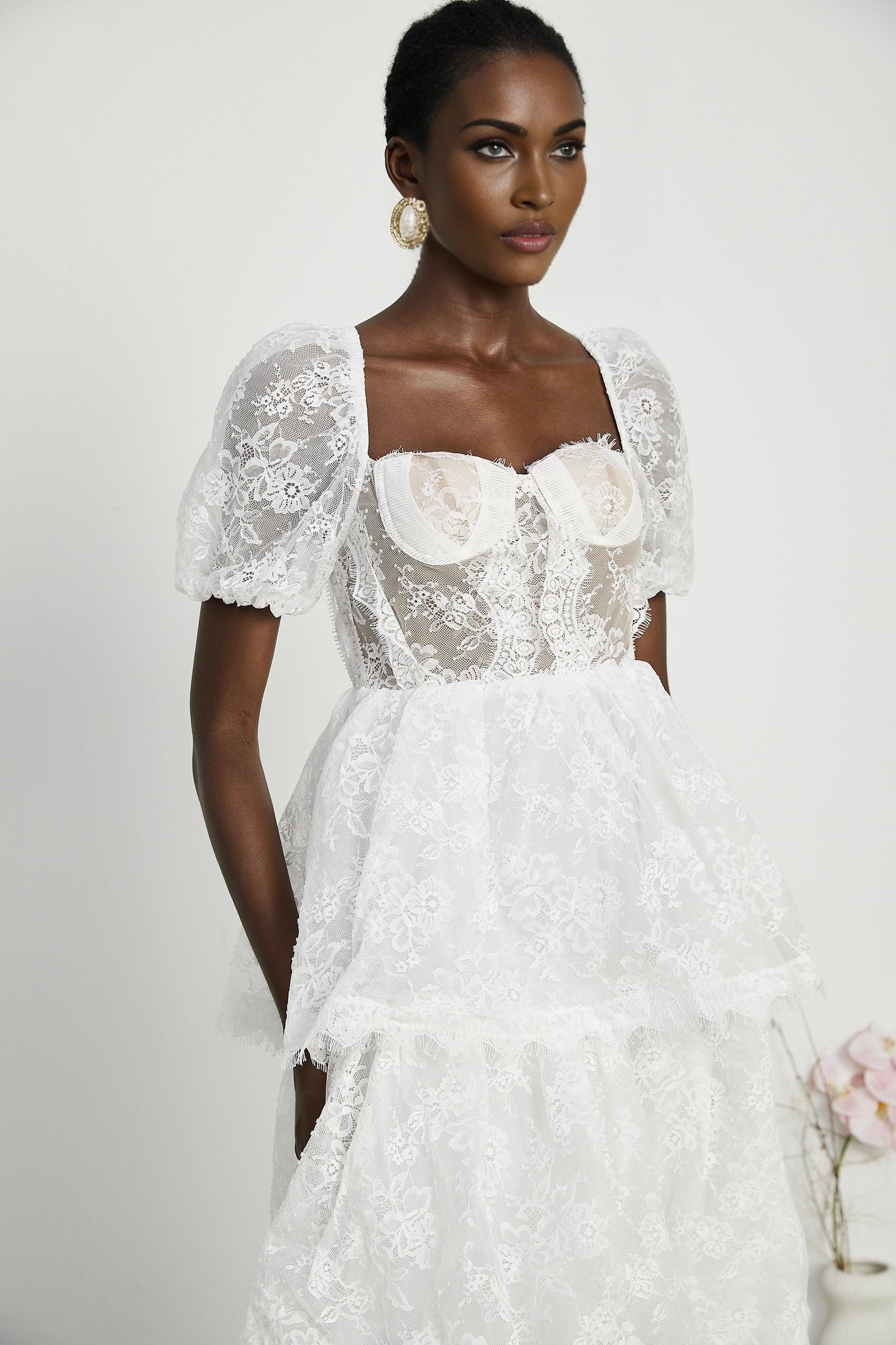 A white lace midi dress with tiered layers by Melisande