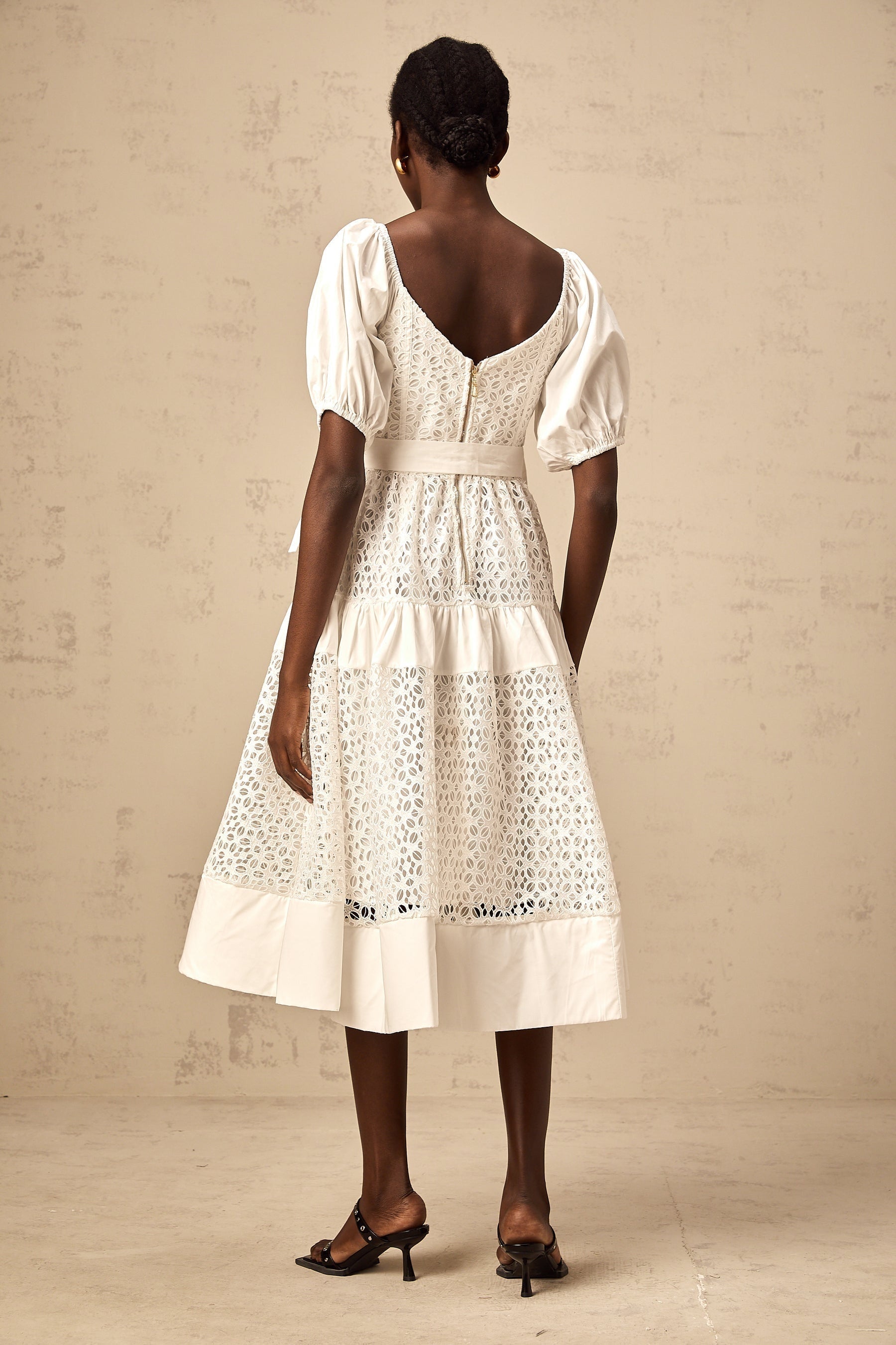A white lace midi dress with tiered skirt and corded lace detailing named Helene
