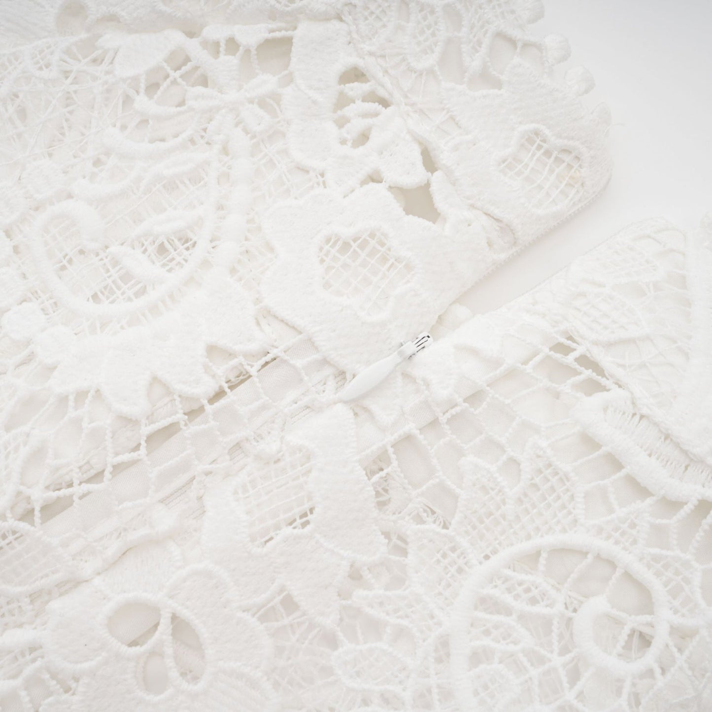White Aline dress with crew neck long sleeves embroidered lace detail cutout design cinch waist flounce hem front button closure and mini length Composed of 70% Cotton 20% Terylene 10% Viscose