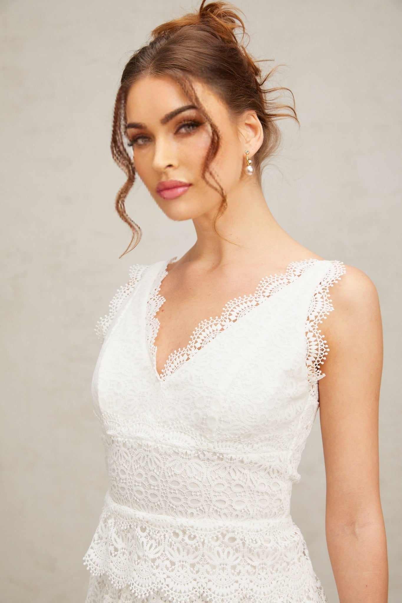 A white lace mini dress with tiered layers featuring a fitted bodice and flared skirt