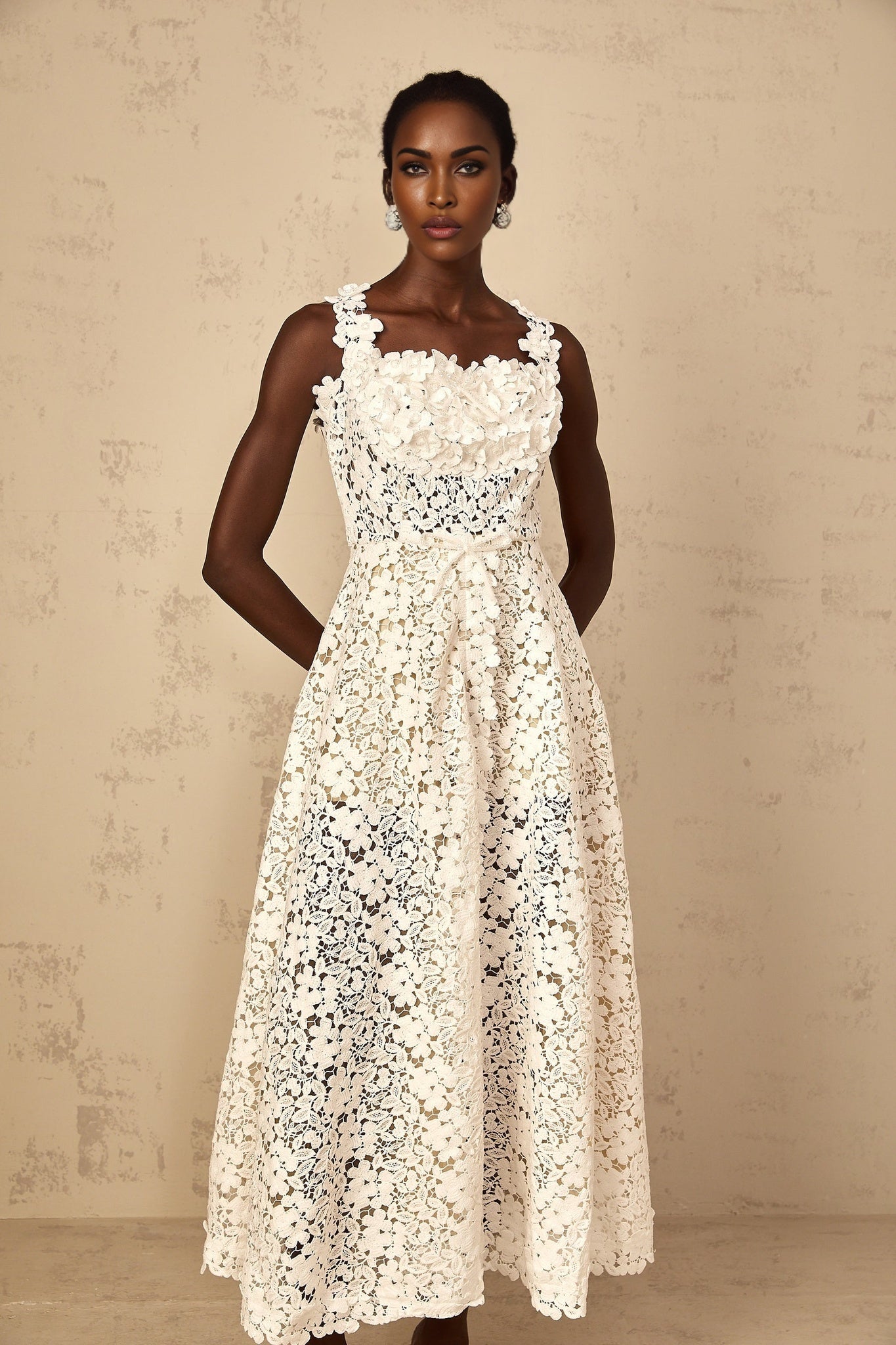 A white maxi dress for women featuring shirred corded lace design with a full length skirt and feminine silhouette
