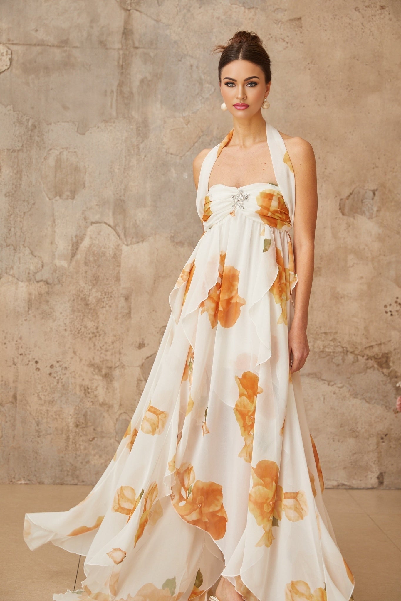 A white maxi dress with floral print featuring ruffled tulle details and a flowing long skirt