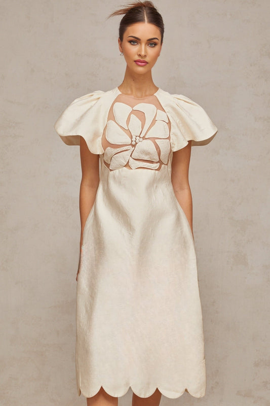 A white midi dress with a floral jacquard pattern featuring a feminine silhouette and delicate flower designs throughout the fabric