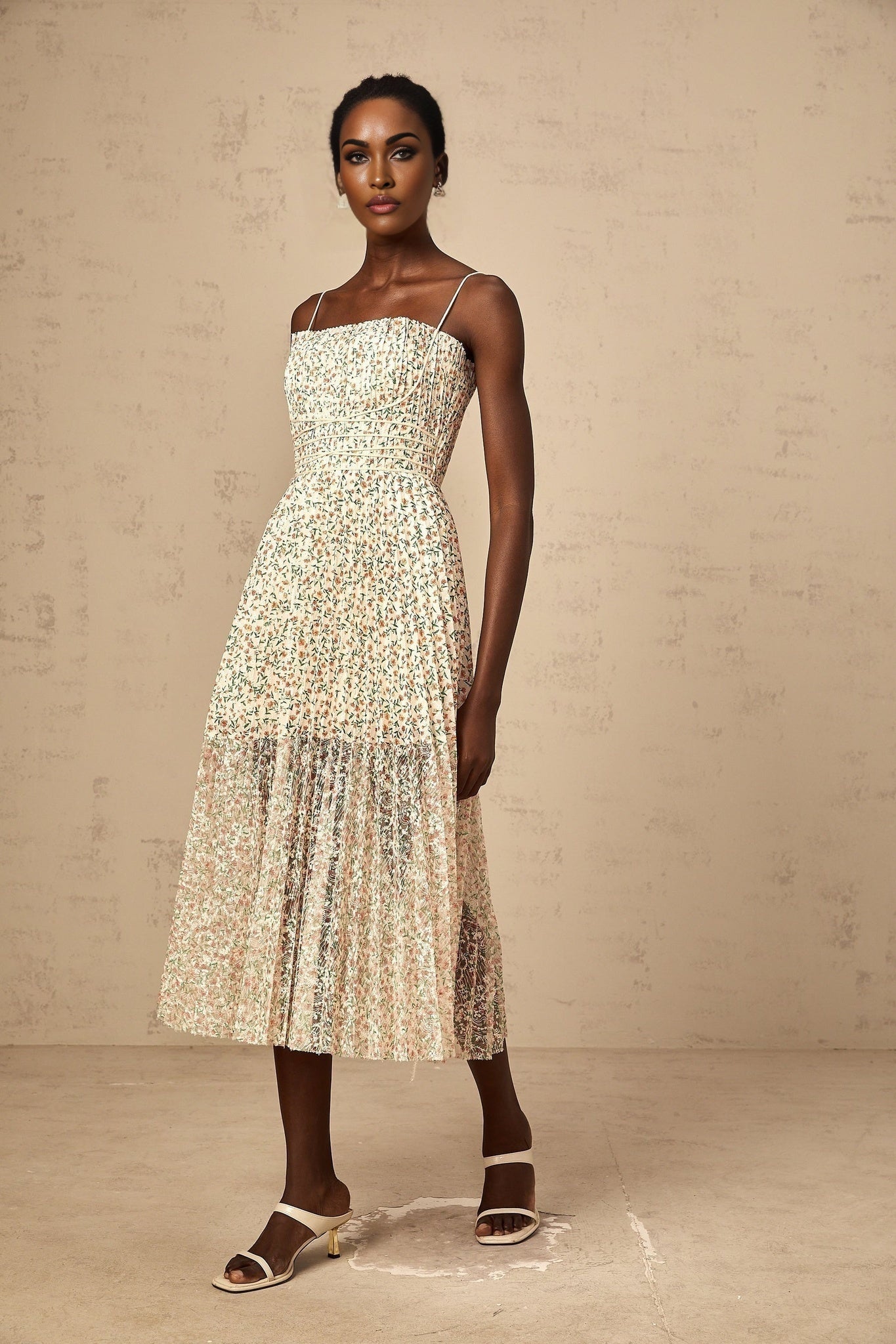 A white midi dress with a floral print pattern and pleated design featuring a feminine silhouette and delicate details