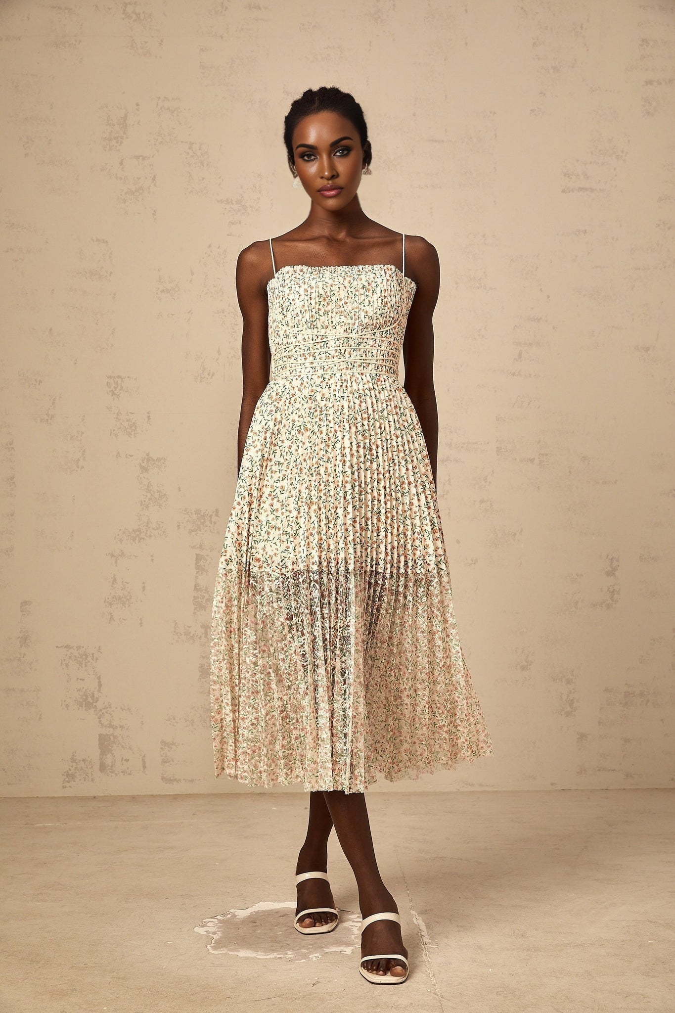A white midi dress with a floral print pattern and pleated design featuring a feminine silhouette and delicate details