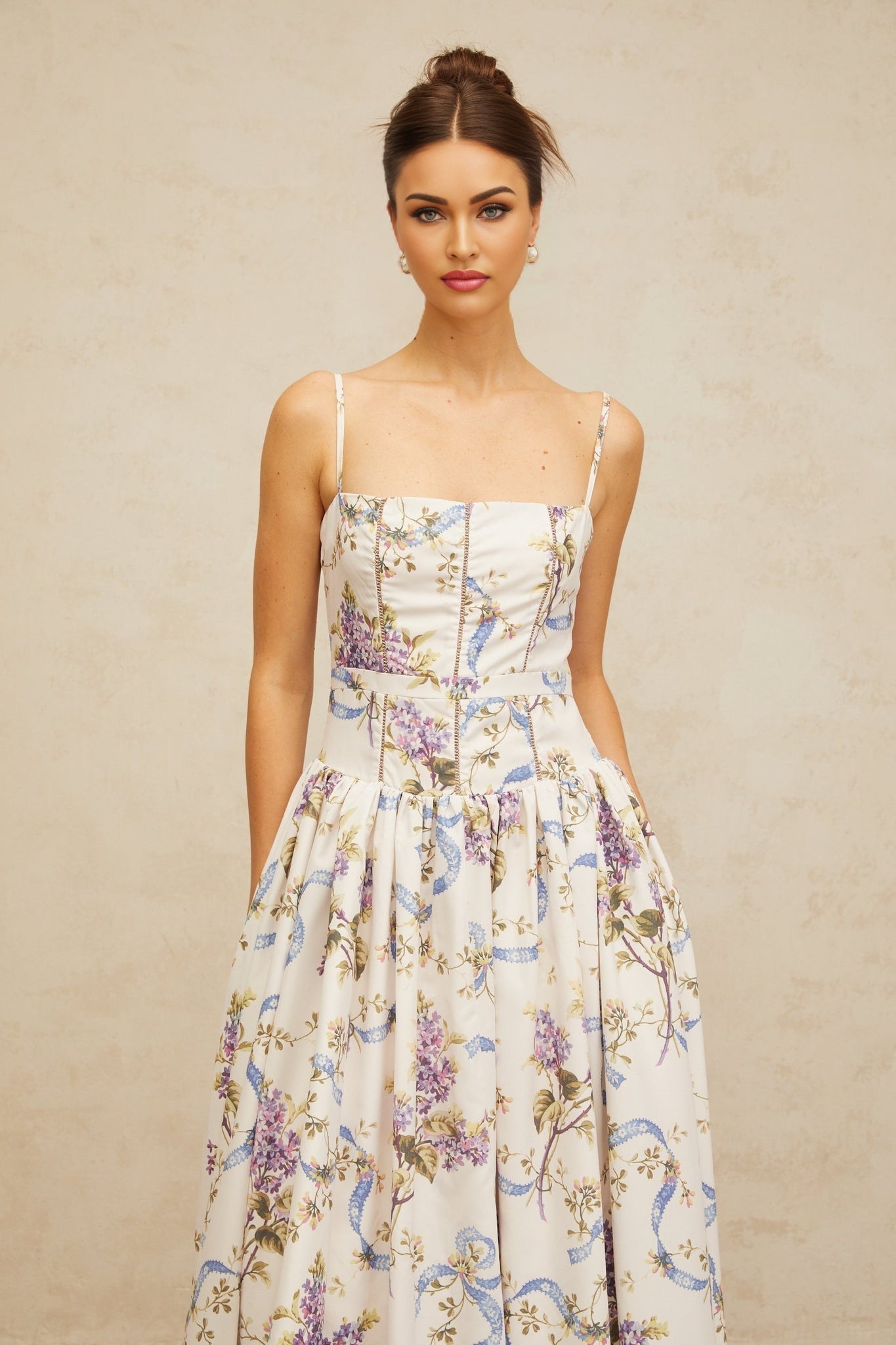 A white midi dress with a floral print pattern covering the fabric The dress features a fitted bodice and flowy skirt reaching mid calf length