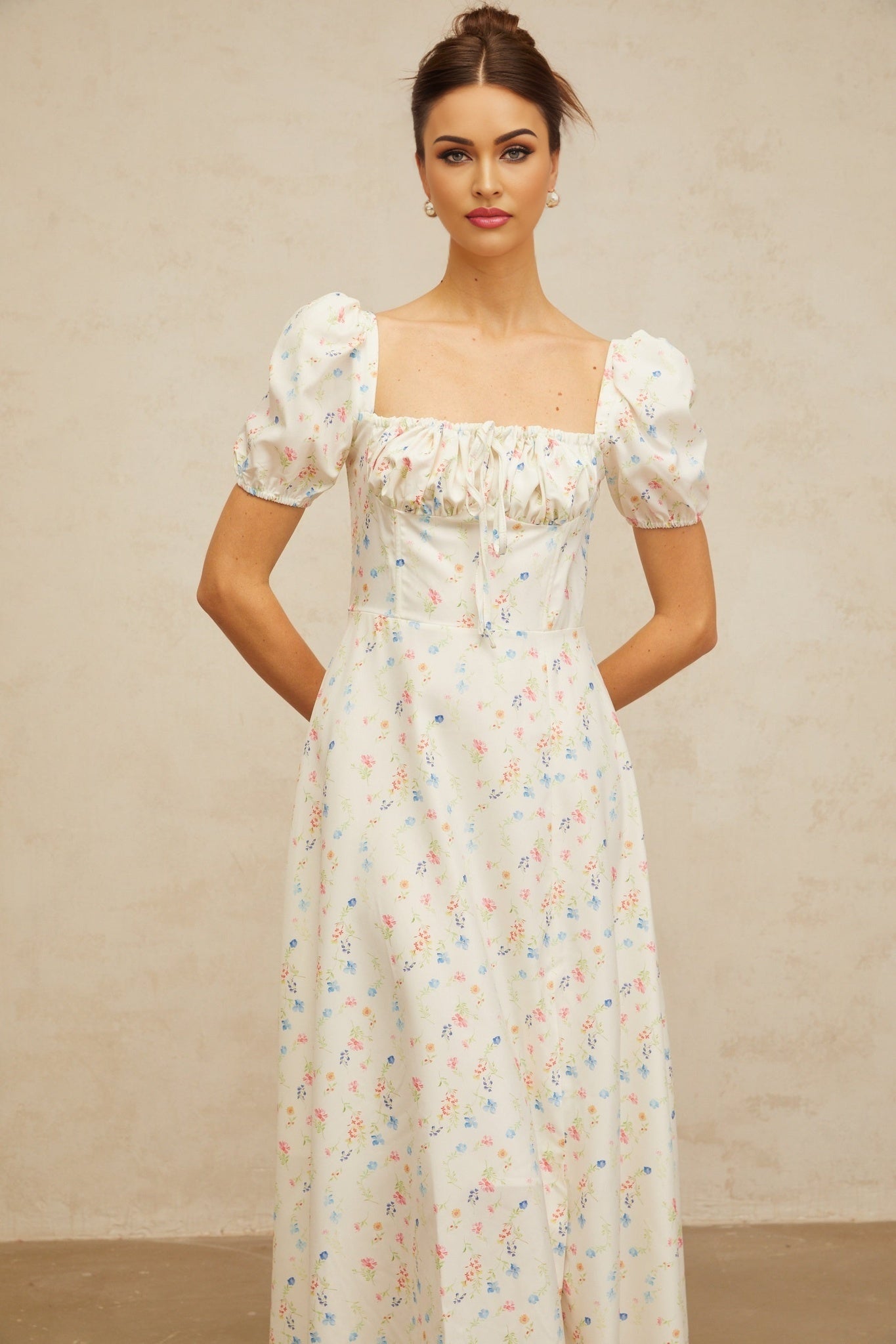 A white midi dress with a floral print pattern featuring a flared skirt design and likely short sleeves or sleeveless style named Eva