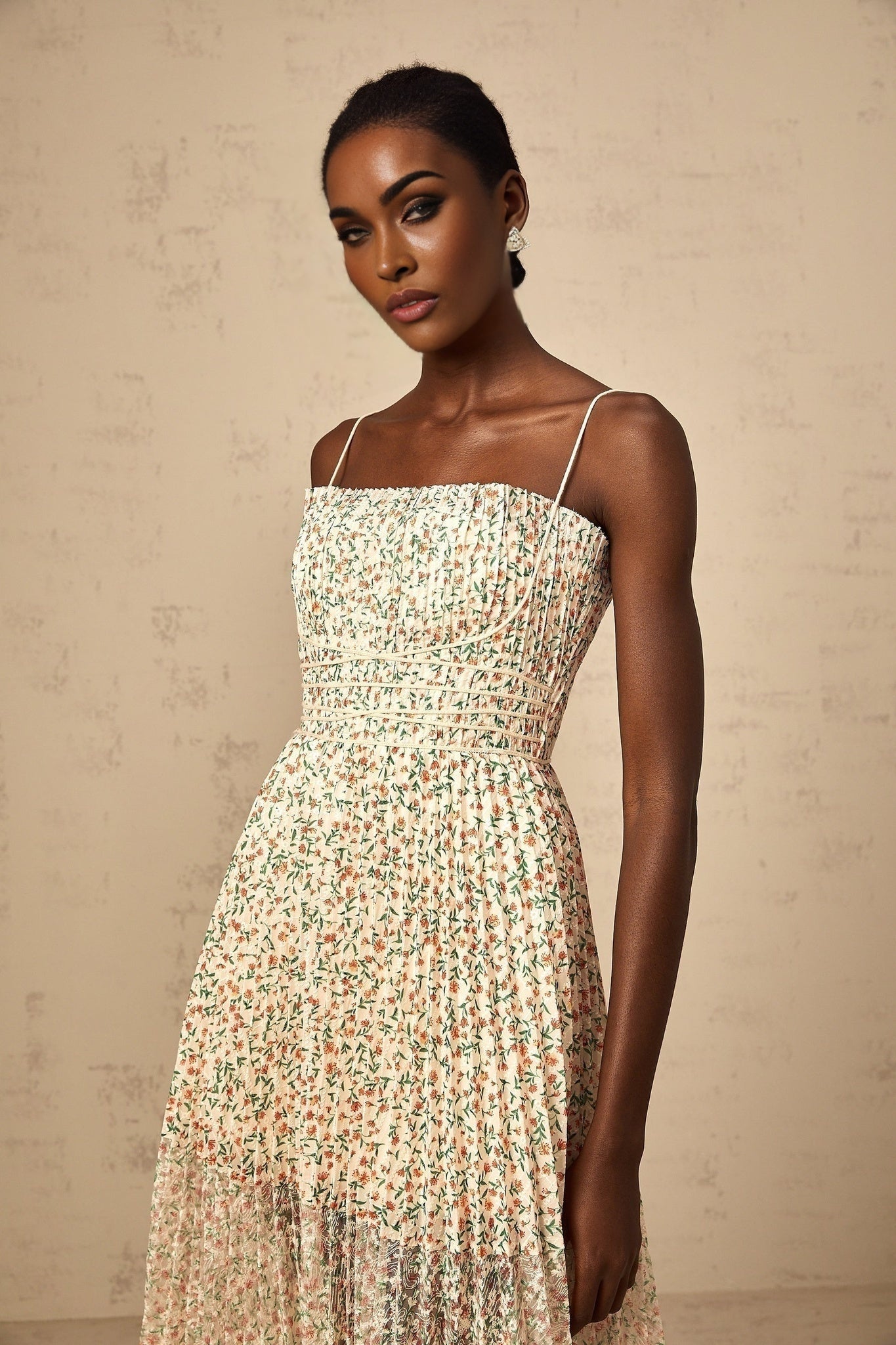 A white midi dress with a floral print pattern featuring pleats and a feminine silhouette named Marion