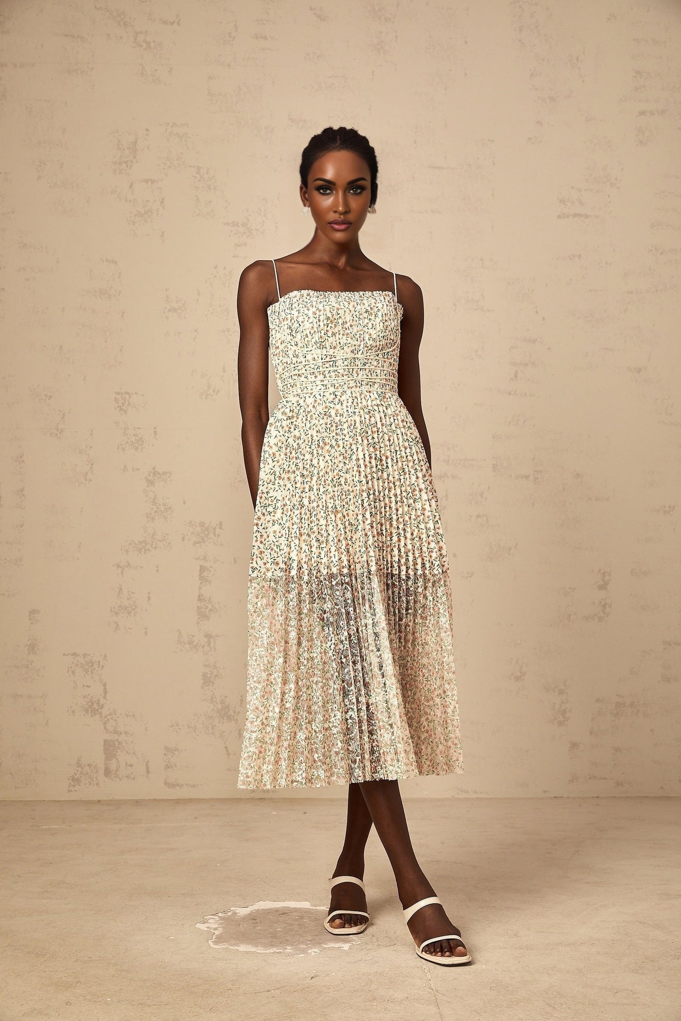 A white midi dress with a floral print pattern featuring pleats and a feminine silhouette named Marion