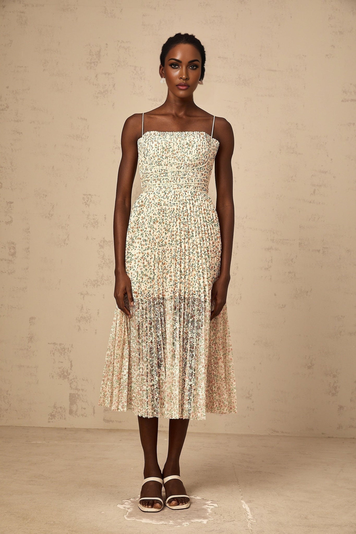 A white midi dress with a floral print pattern featuring pleats and a Marion design