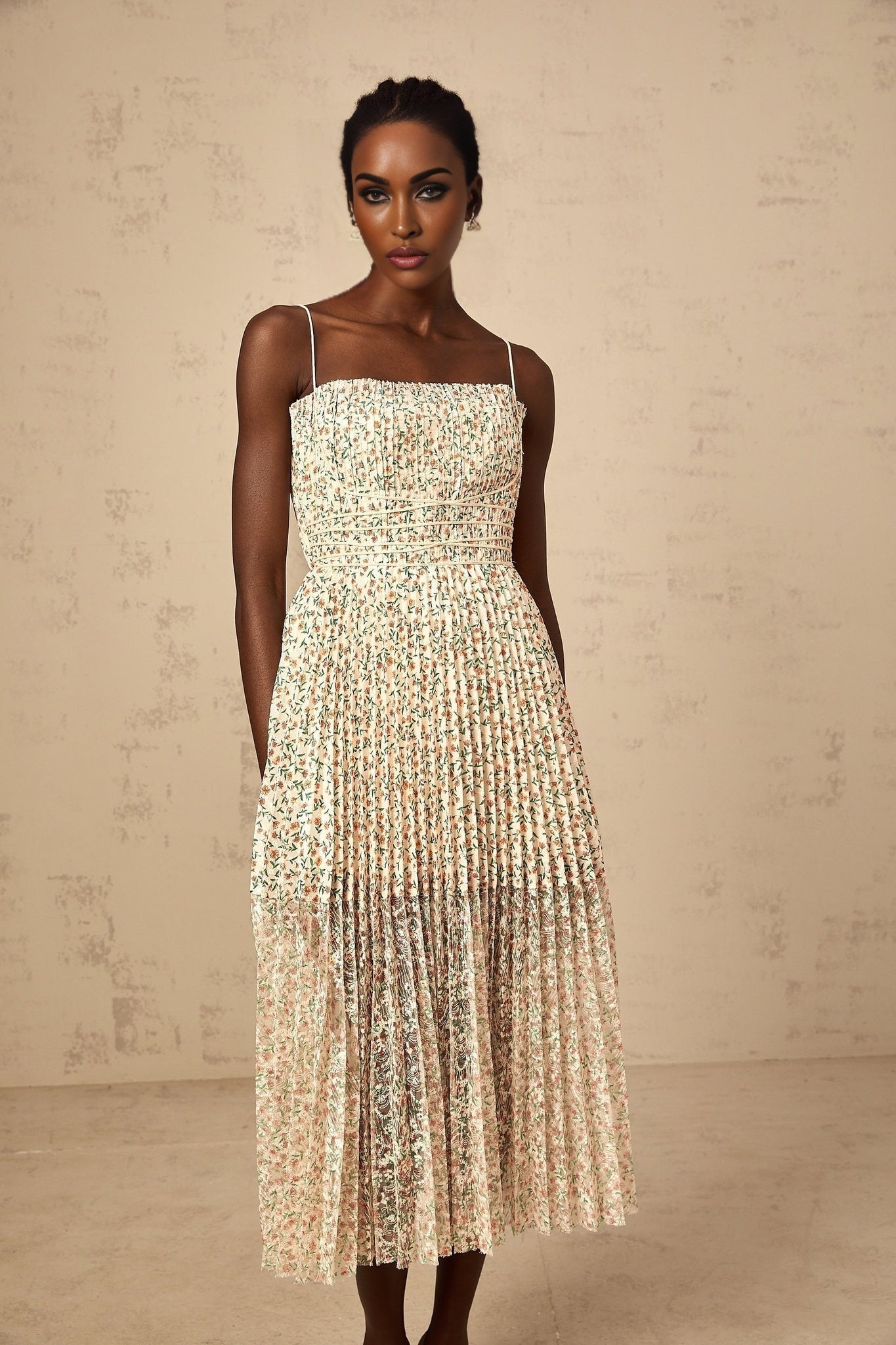 A white midi dress with a floral print pattern featuring pleats and the name Marion