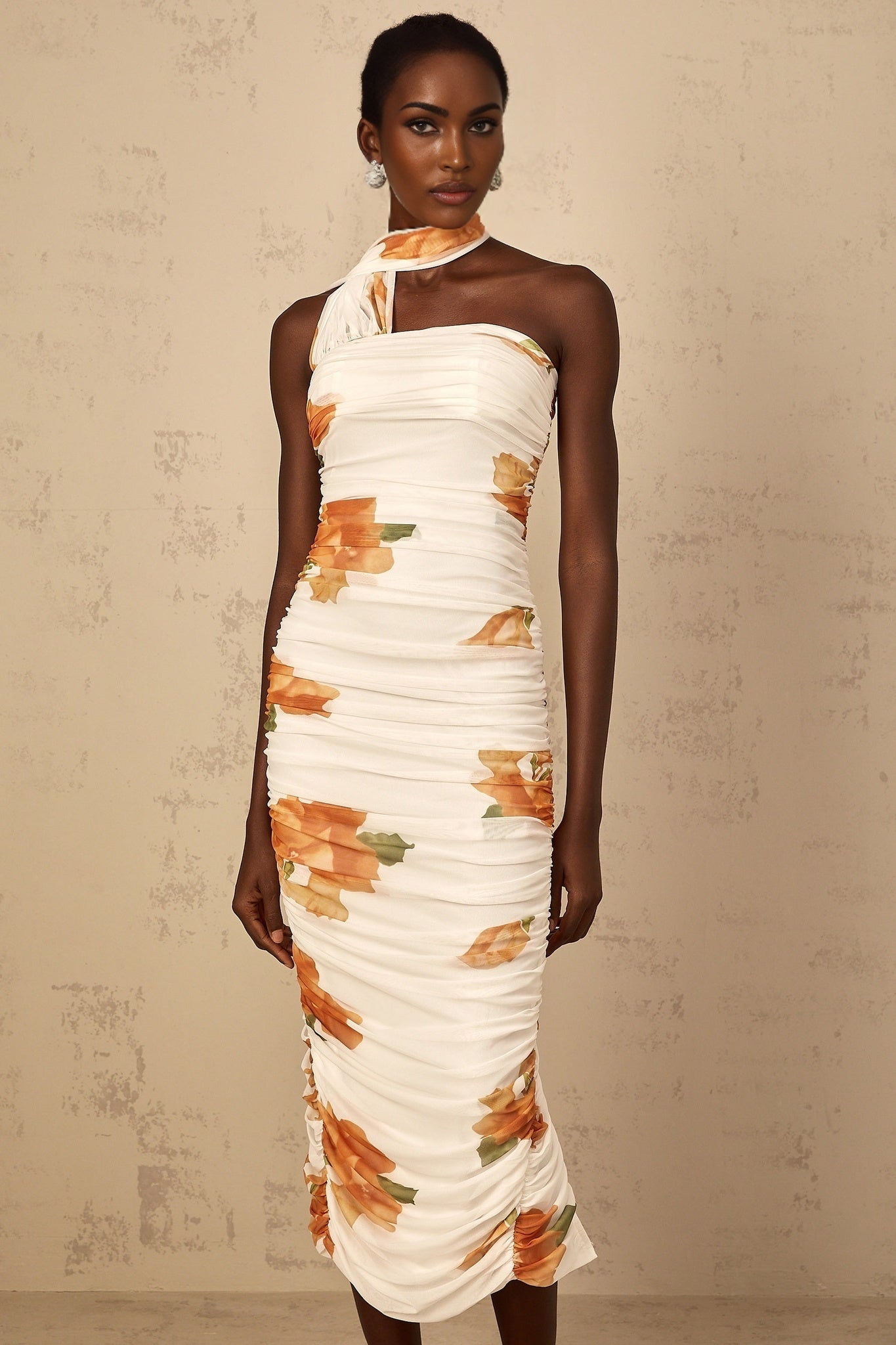 A white midi dress with a floral print pattern made of ruched tulle fabric featuring a Frida design