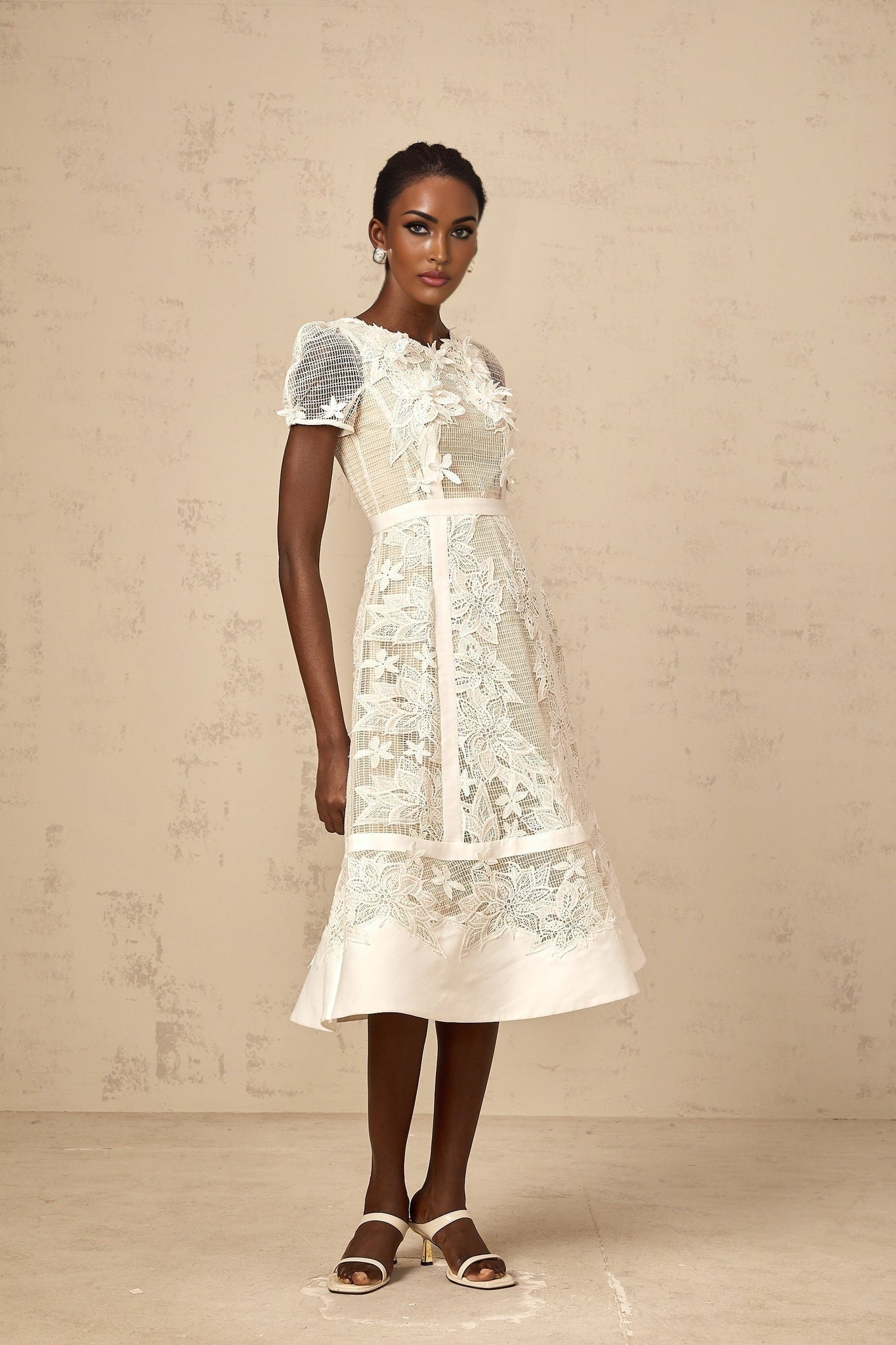 A white midi dress with delicate flower embroidery featuring a feminine design and elegant silhouette