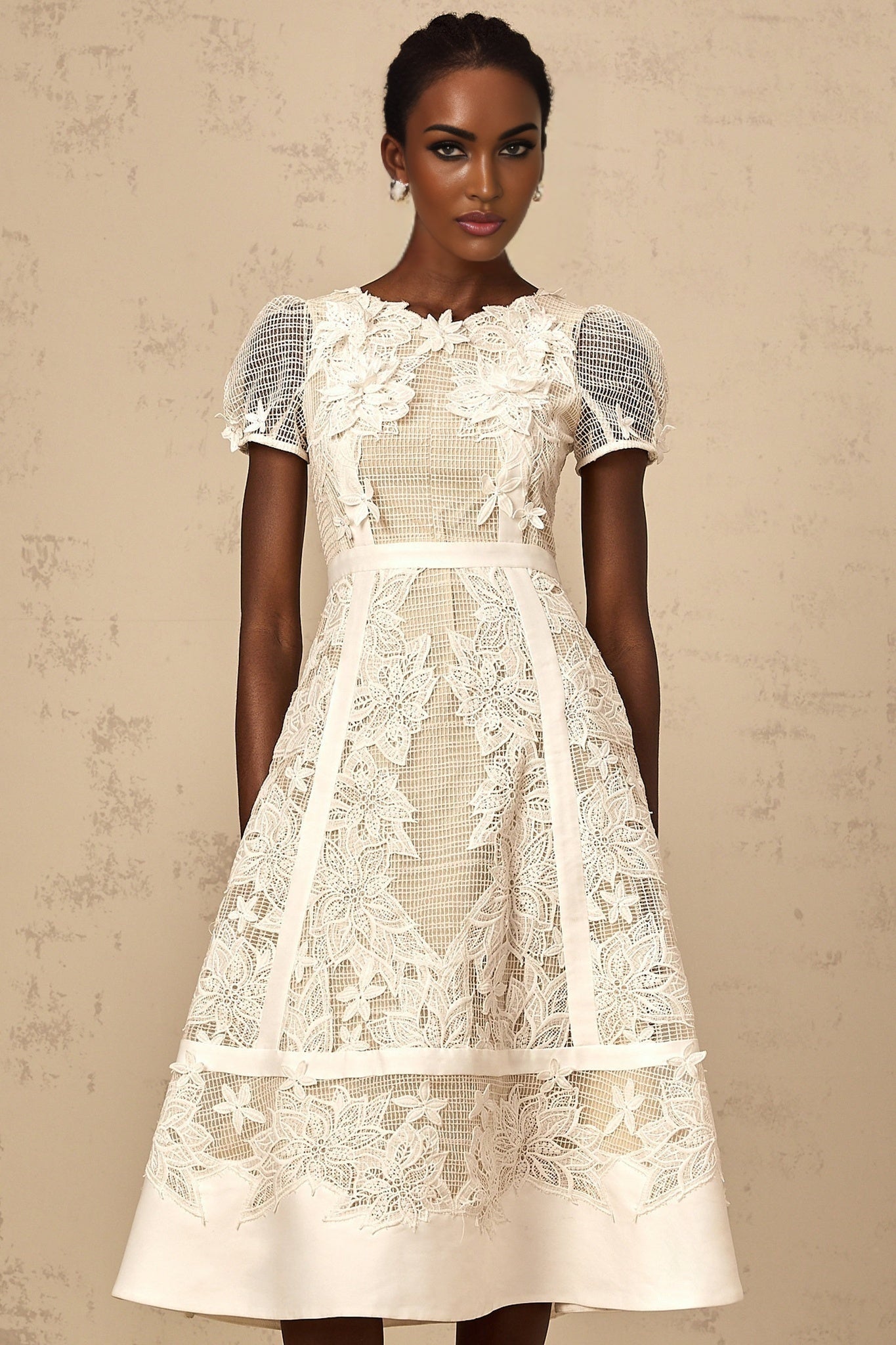 A white midi dress with floral embroidery details featuring a delicate Clemence design