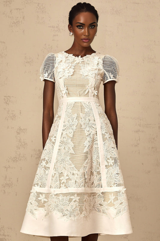 A white midi dress with floral embroidery details featuring a delicate Clemence design