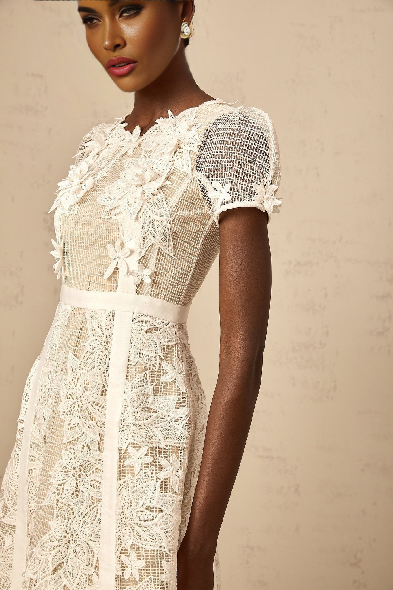 A white midi dress with floral embroidery details featuring a design by Clémence