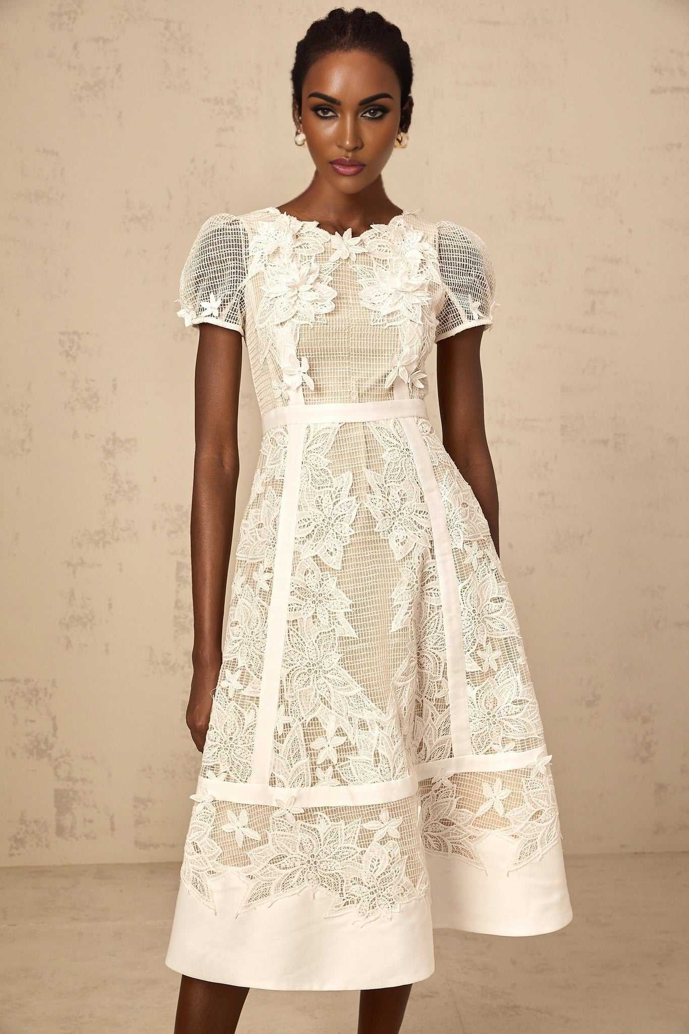 A white midi dress with floral embroidery featuring a feminine silhouette and delicate flower patterns
