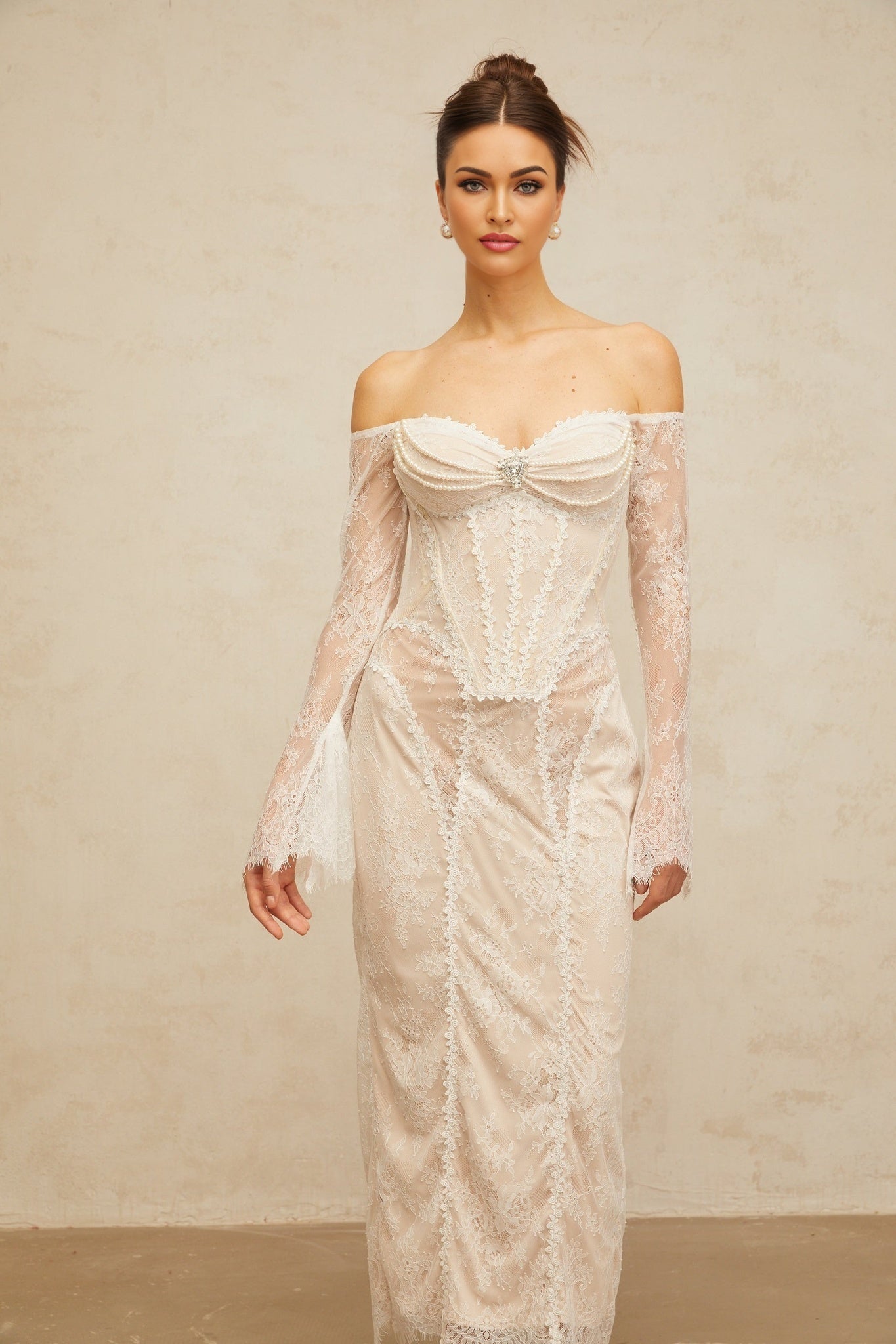 A white midi dress with floral lace embellishments and a delicate embroidered pattern throughout the bodice and skirt