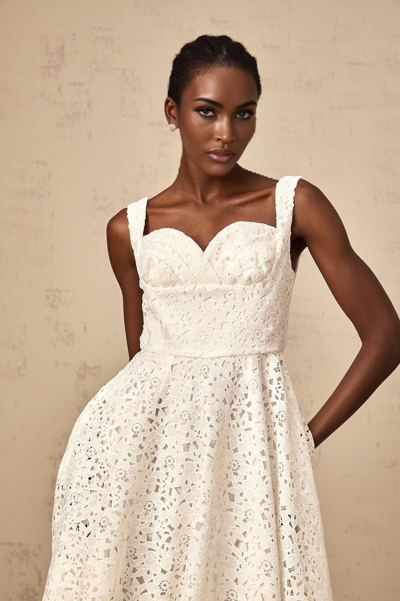 A white midi dress with floral lace pattern and details named Nicolette