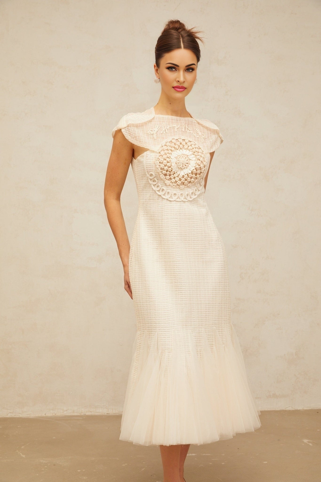 A white midi dress with jacquard pattern and tulle panel details featuring a feminine silhouette and delicate fabric texture