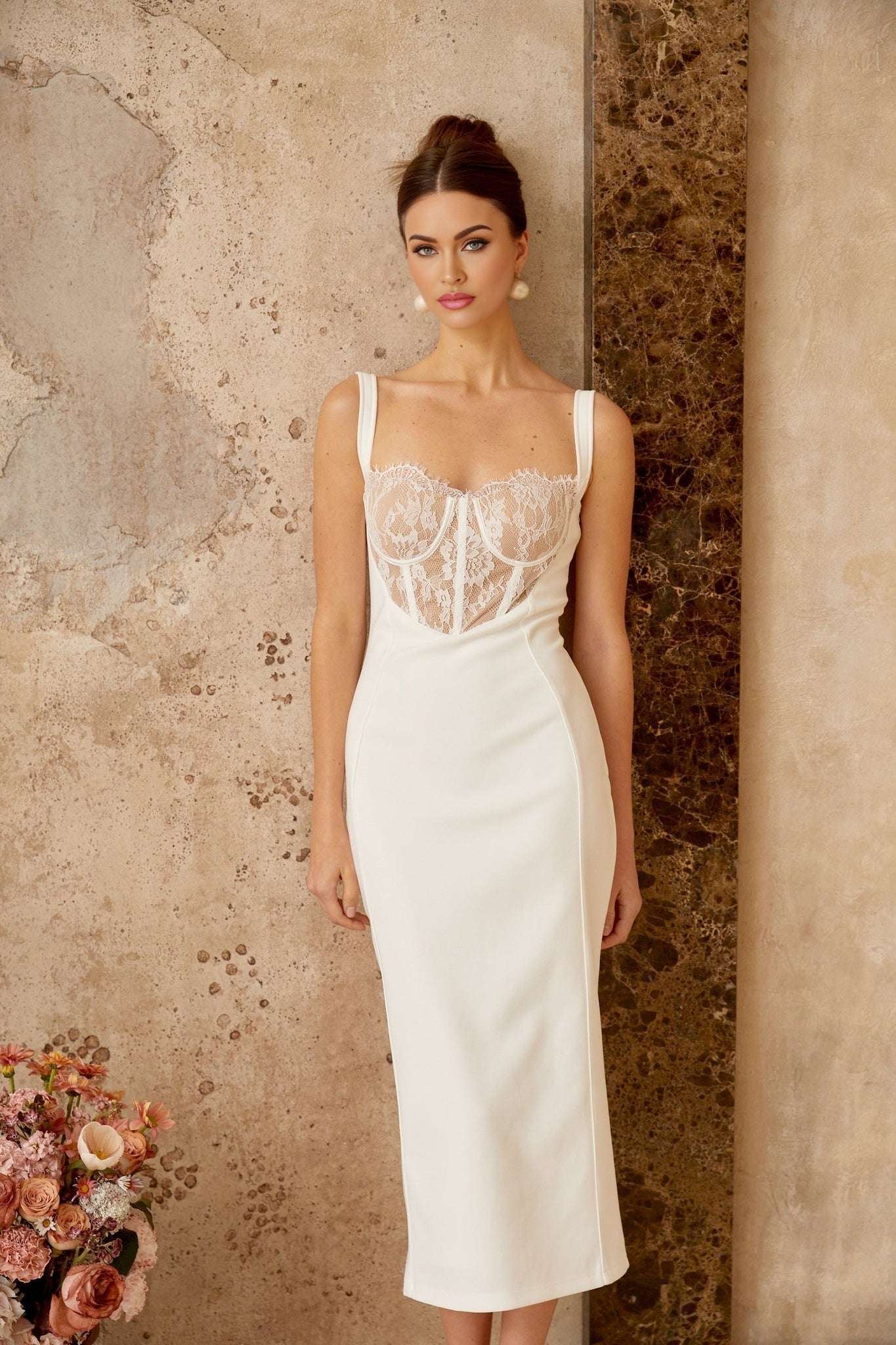 A white midi dress with lace panels and corsetstyle bodice featuring a fitted silhouette and delicate feminine design