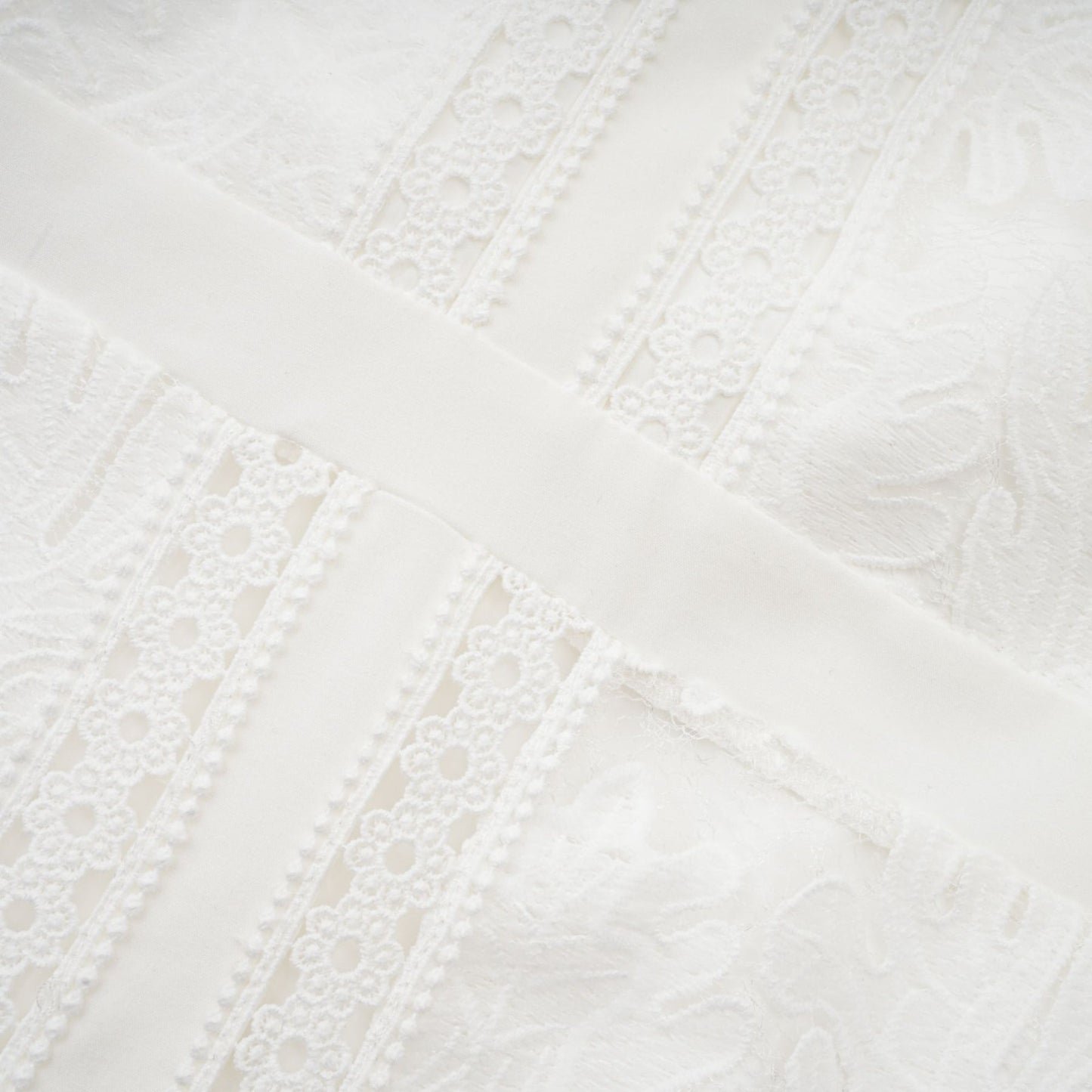 A white midi dress with panelled design and embroidery details named Madeleine featuring a feminine silhouette and delicate pattern work
