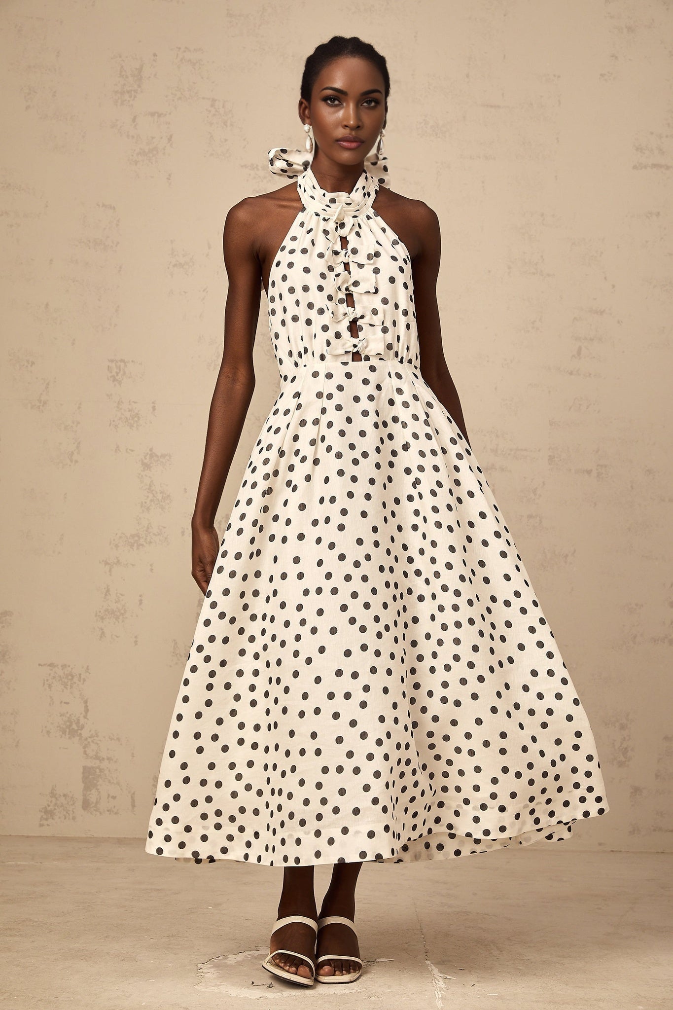A white midi dress with polka dots and a bow detail named Audrey