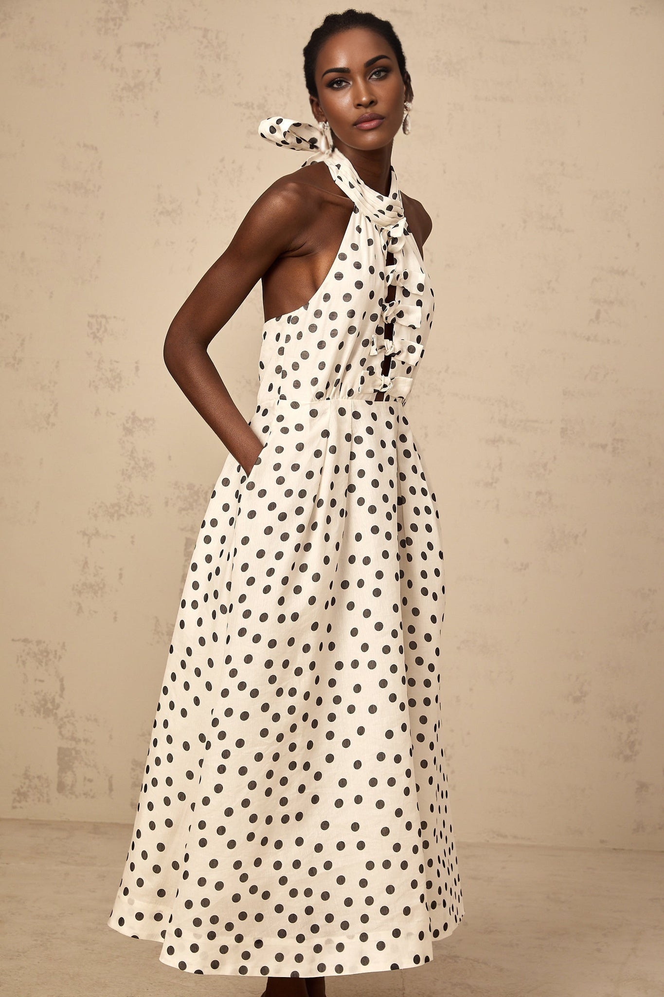 A white midi dress with polka dots and a bow detail named Audrey