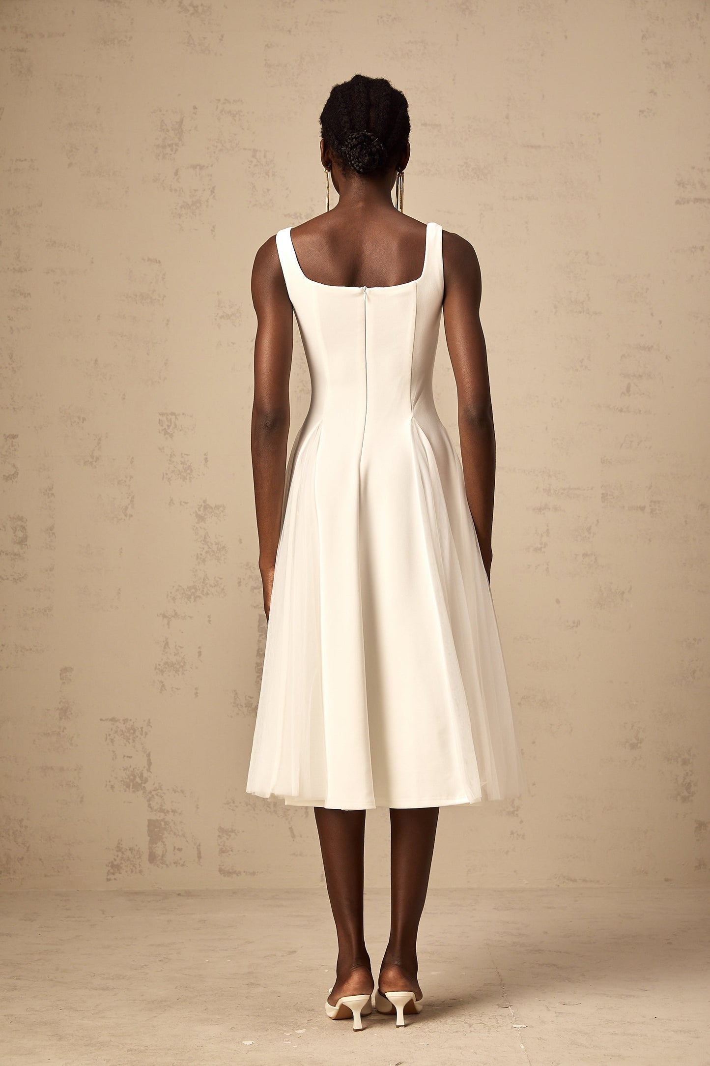 A white midi dress with tulle fabric featuring godet inserts and a flowy silhouette named Danielle