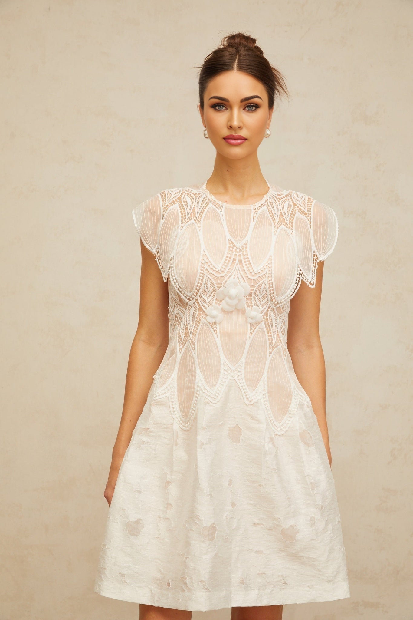 A white mini dress with 3D floral lace petals and corded lace details featuring a delicate and feminine design