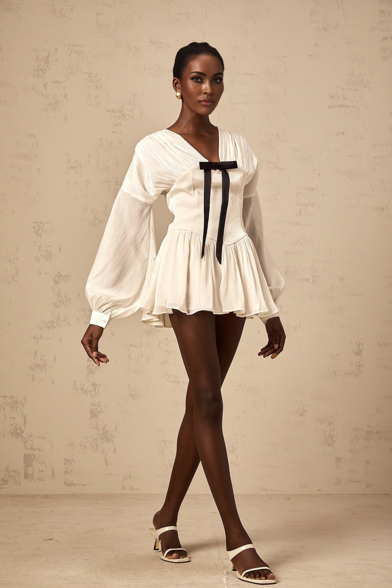 A white mini dress with a bowknot detail and glitter accents named Lina