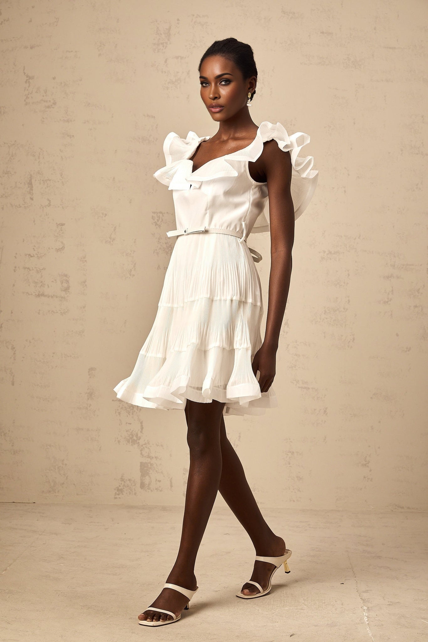 A white mini dress with a frilled neckline and pleated skirt named Eliane