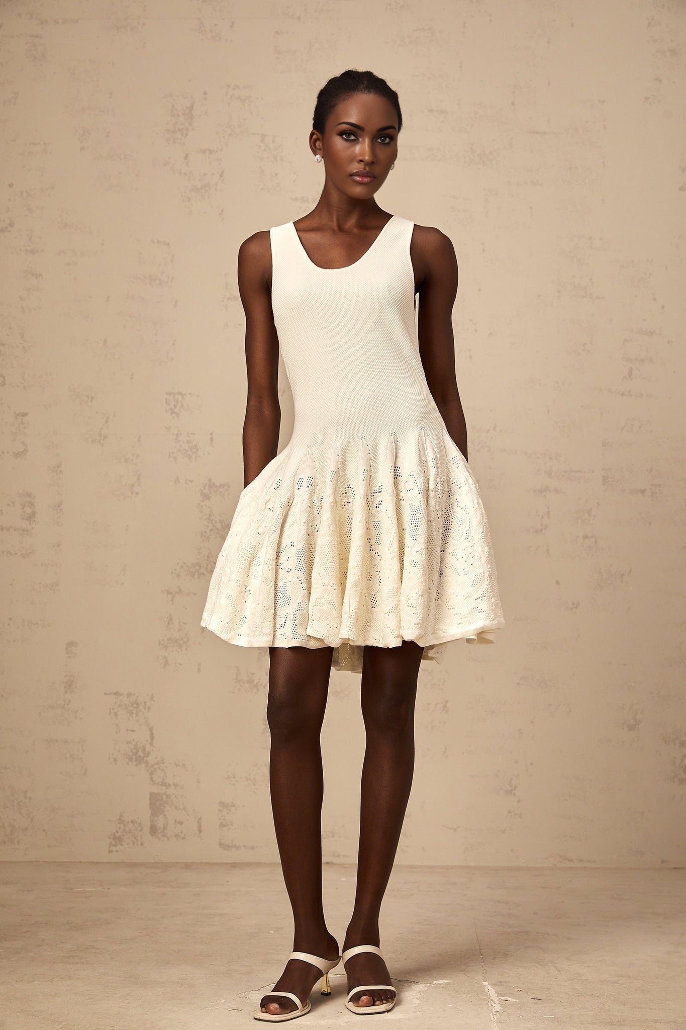 A white mini dress with a jacquard knit pattern named Eleonore worn by a model standing against a plain background