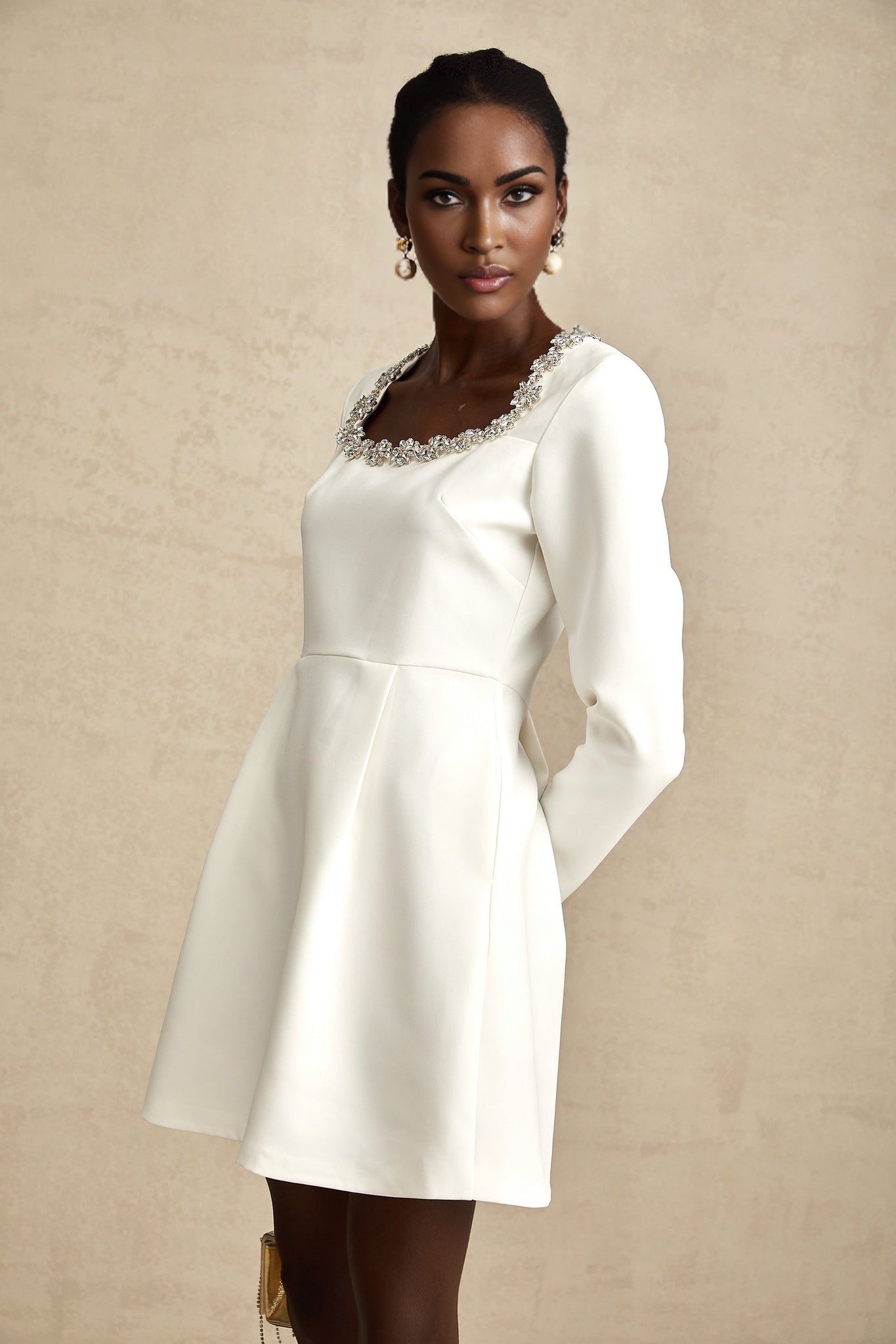 A white mini dress with an Aline silhouette adorned with crystal embellishments featuring the Angelique design