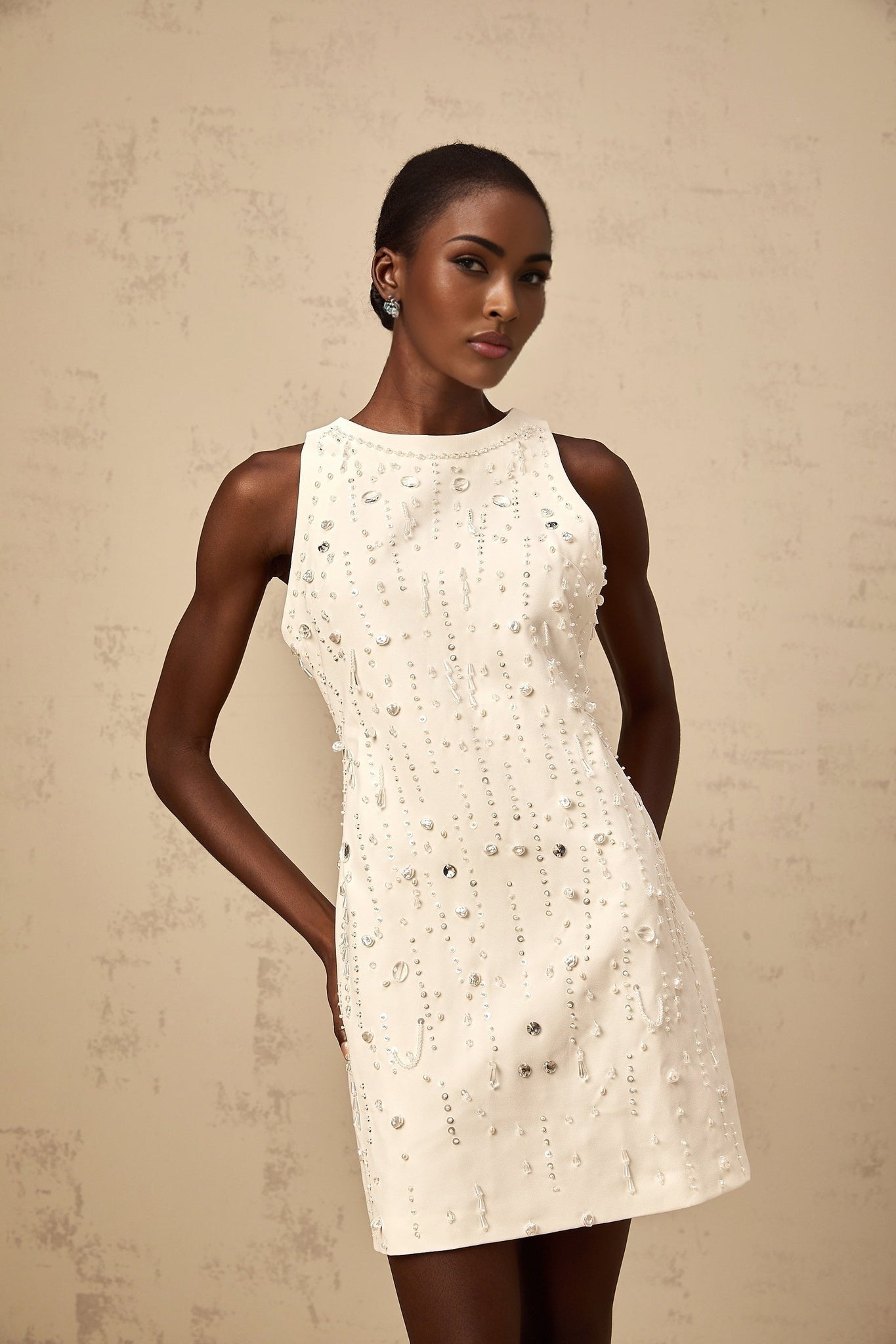 A white mini dress with an Aline silhouette featuring embellishments and named Flavie