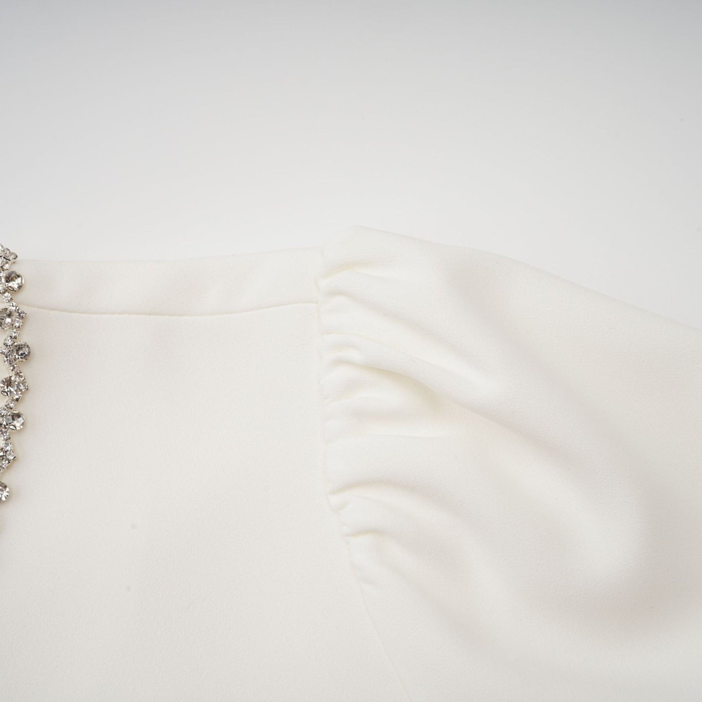 A white mini dress with crystal embellishments named Berenice