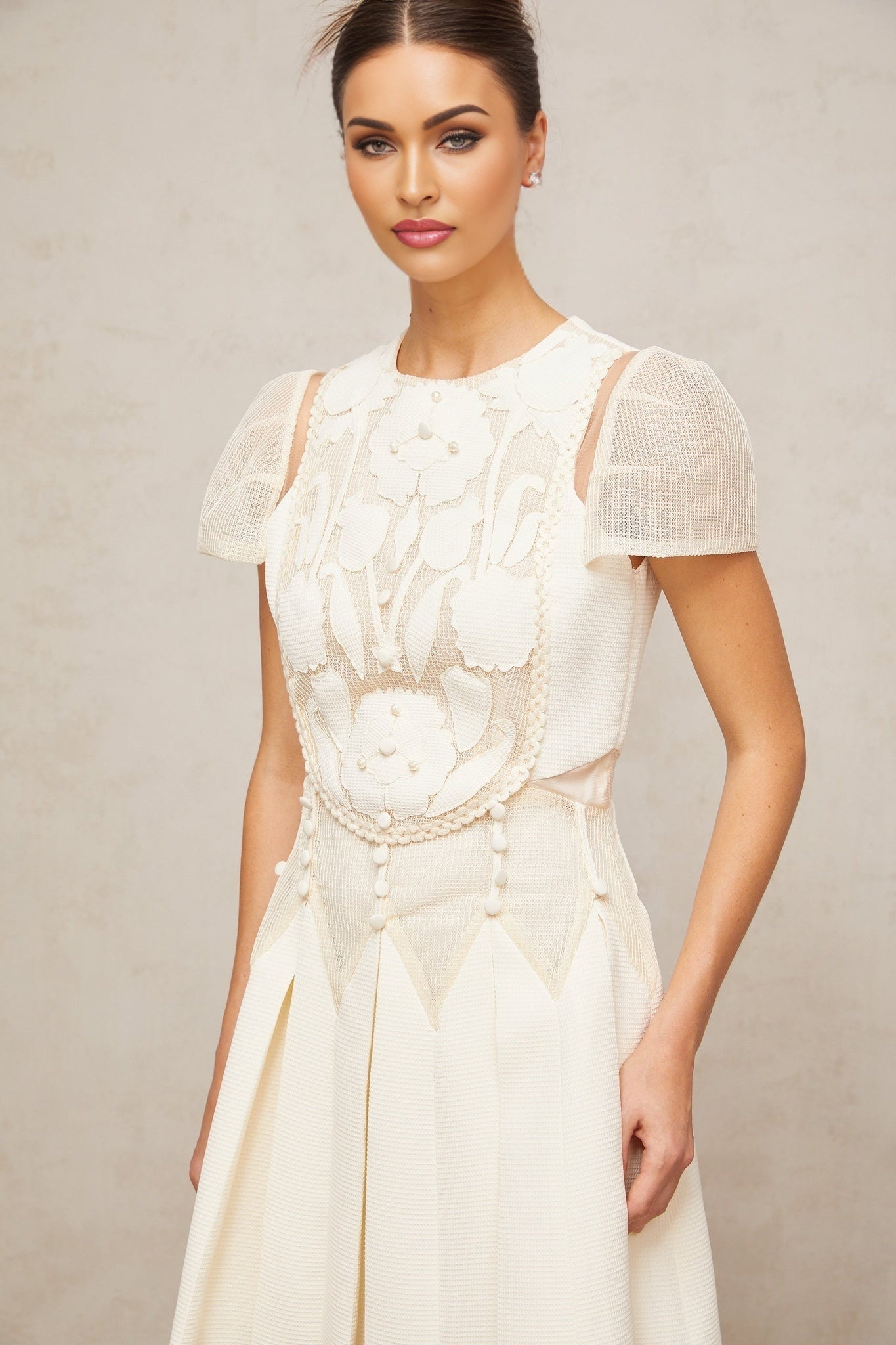 A white mini dress with delicate flower embroidery details covering the fabric Maelle brand