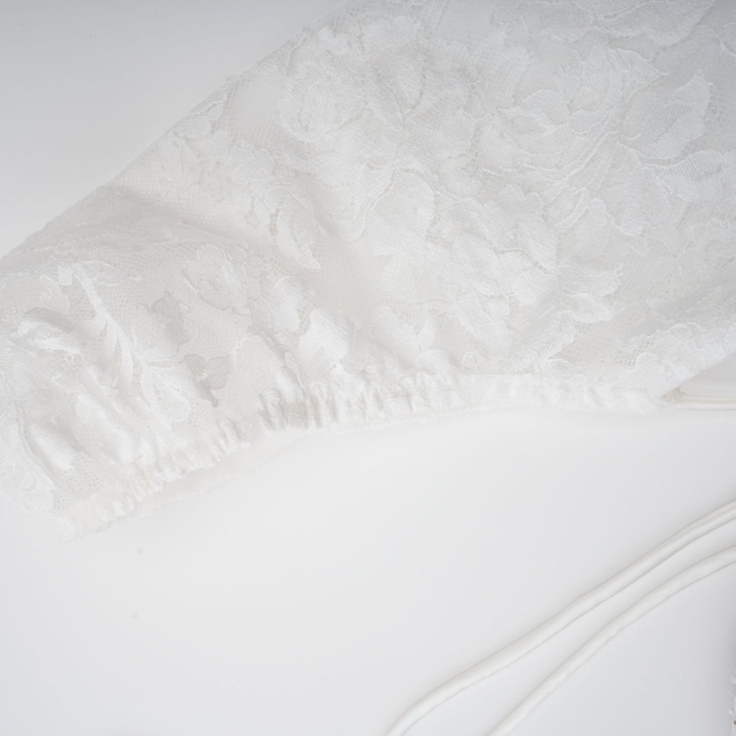 A white mini dress with floral lace pattern featuring a corset style bodice and short skirt