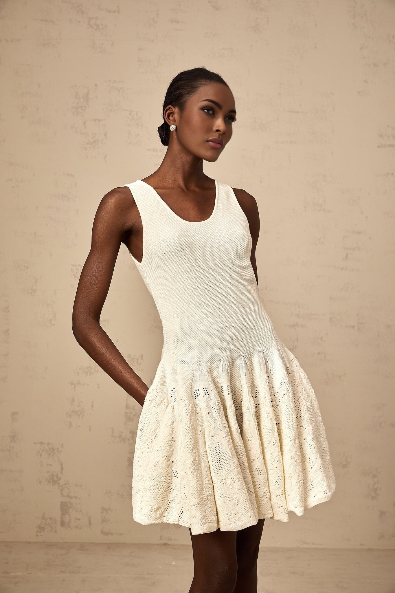 A white mini dress with jacquard knit pattern named Eleonore featuring a short hemline and textured fabric design