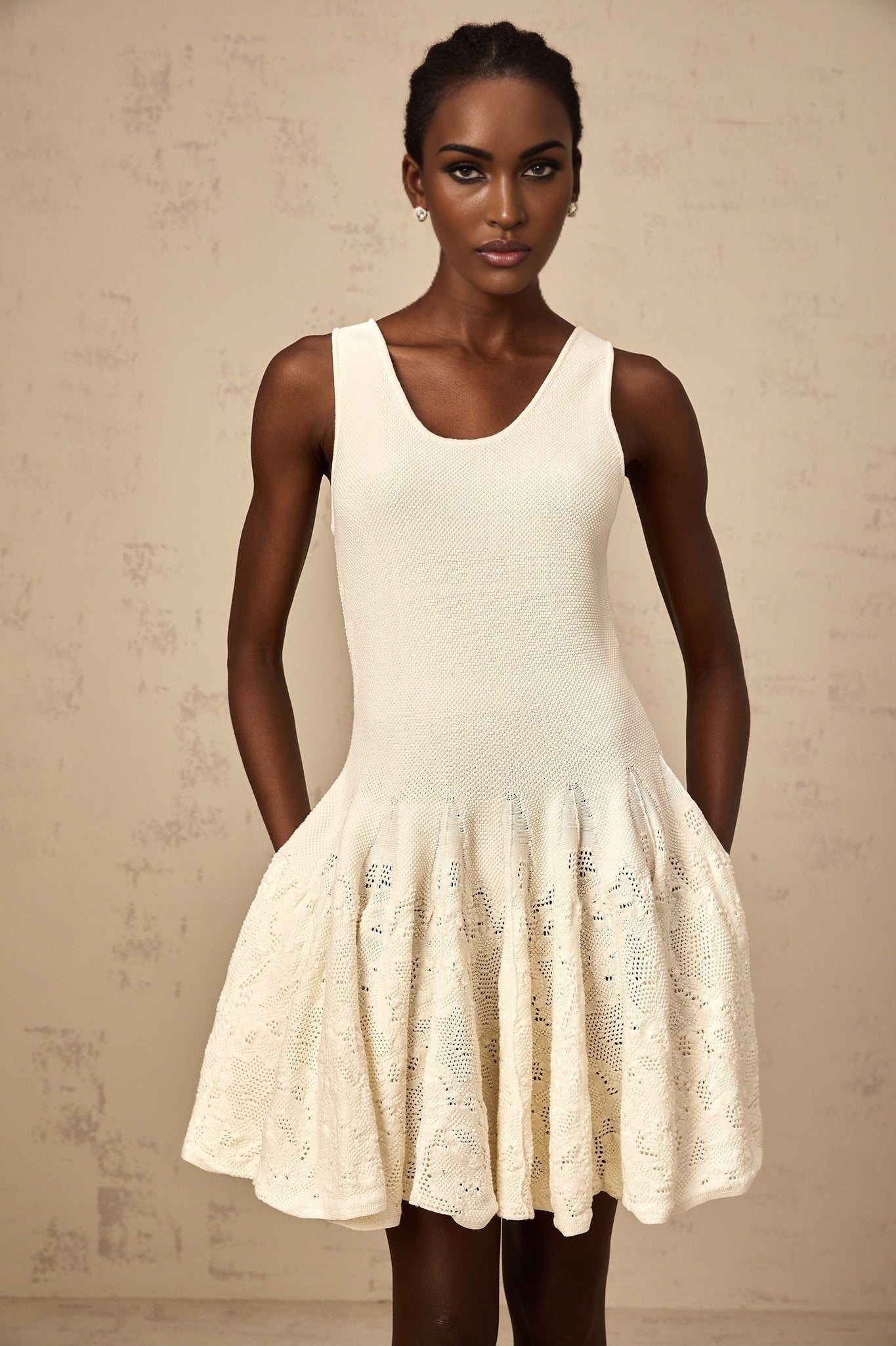 A white mini dress with jacquard knit pattern named Eleonore worn by a model against a plain background