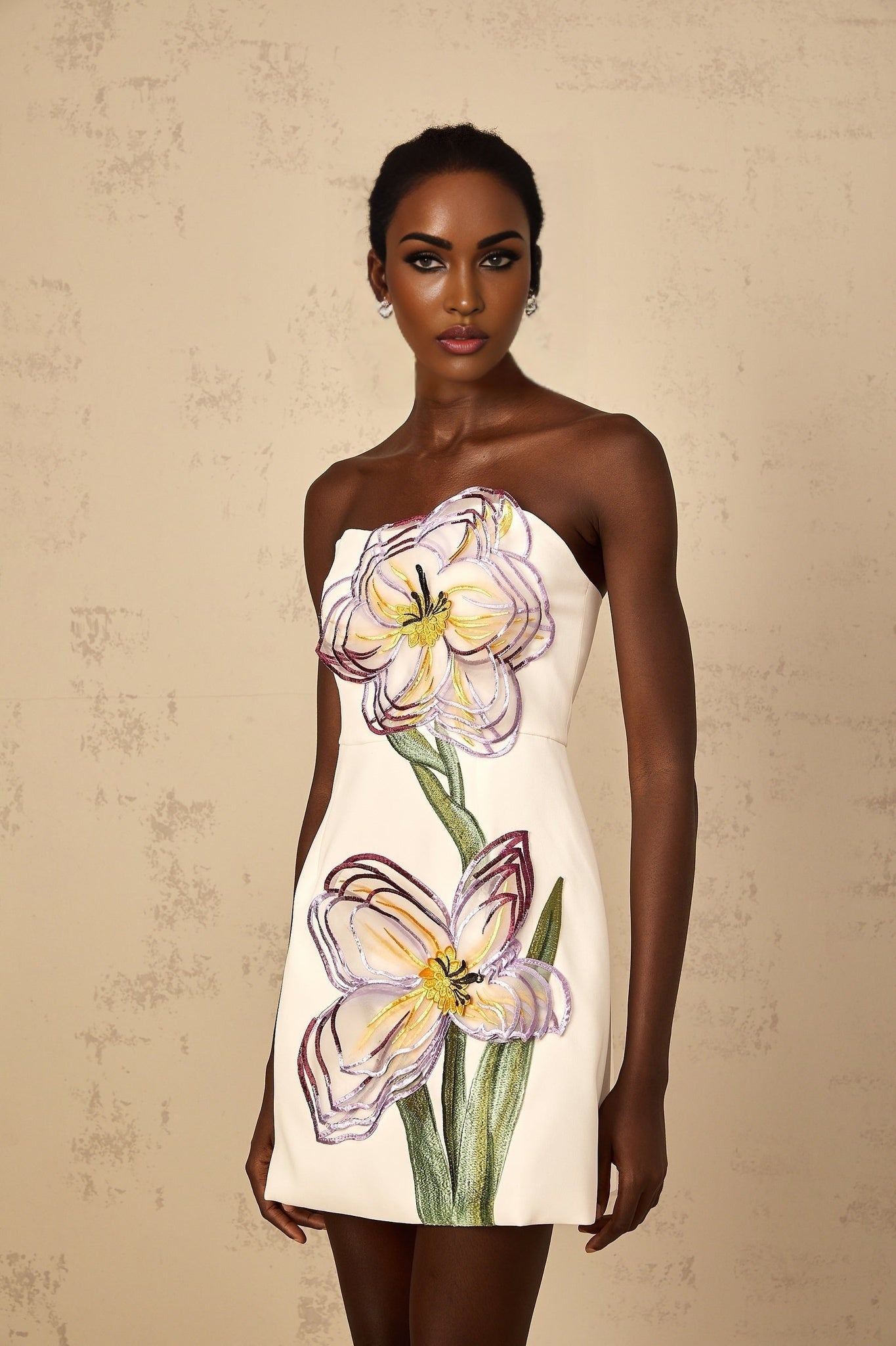 A white off shoulder mini dress with sequin floral embroidery worn by a woman named Irene