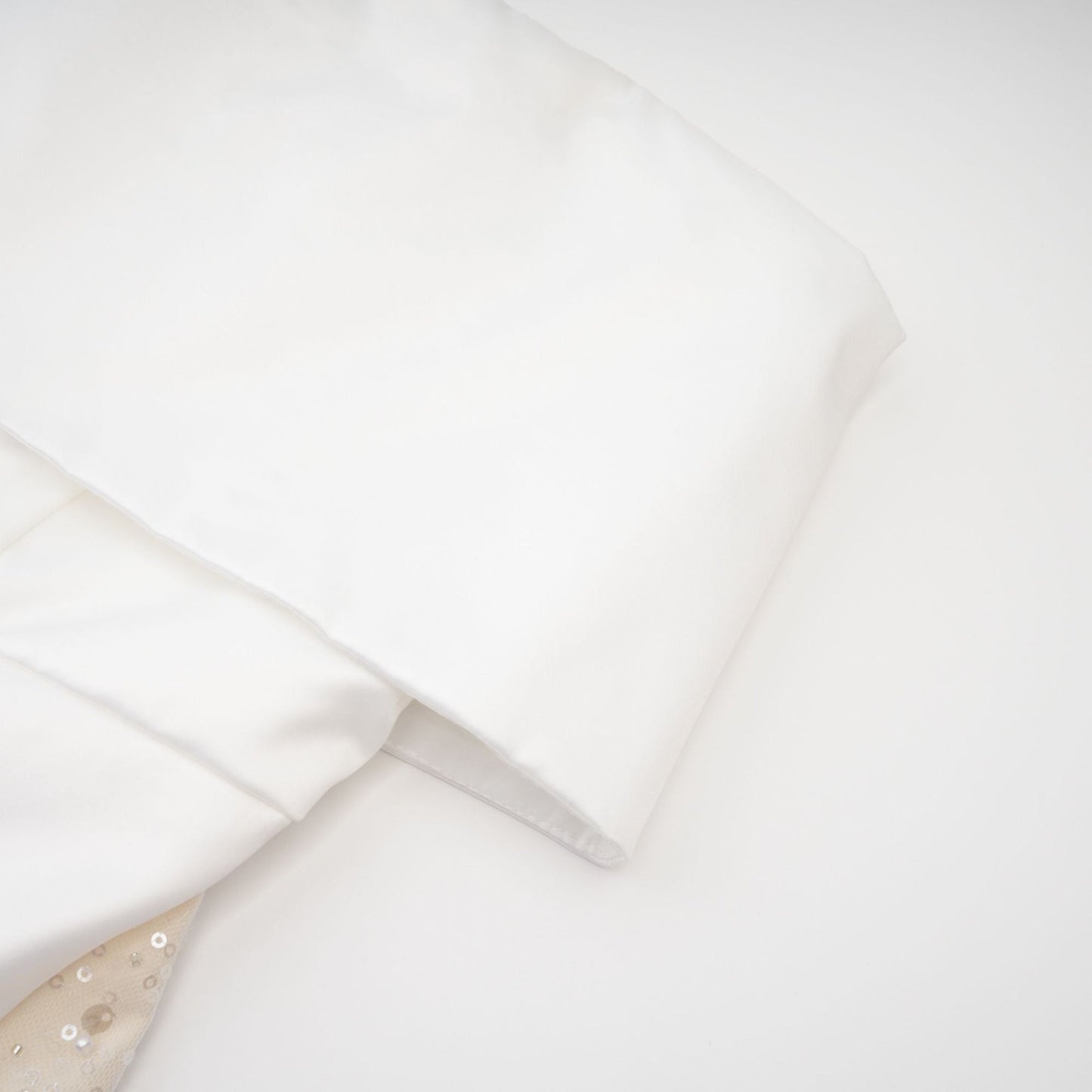 A white off the shoulder dress with a flowing silhouette and delicate design details