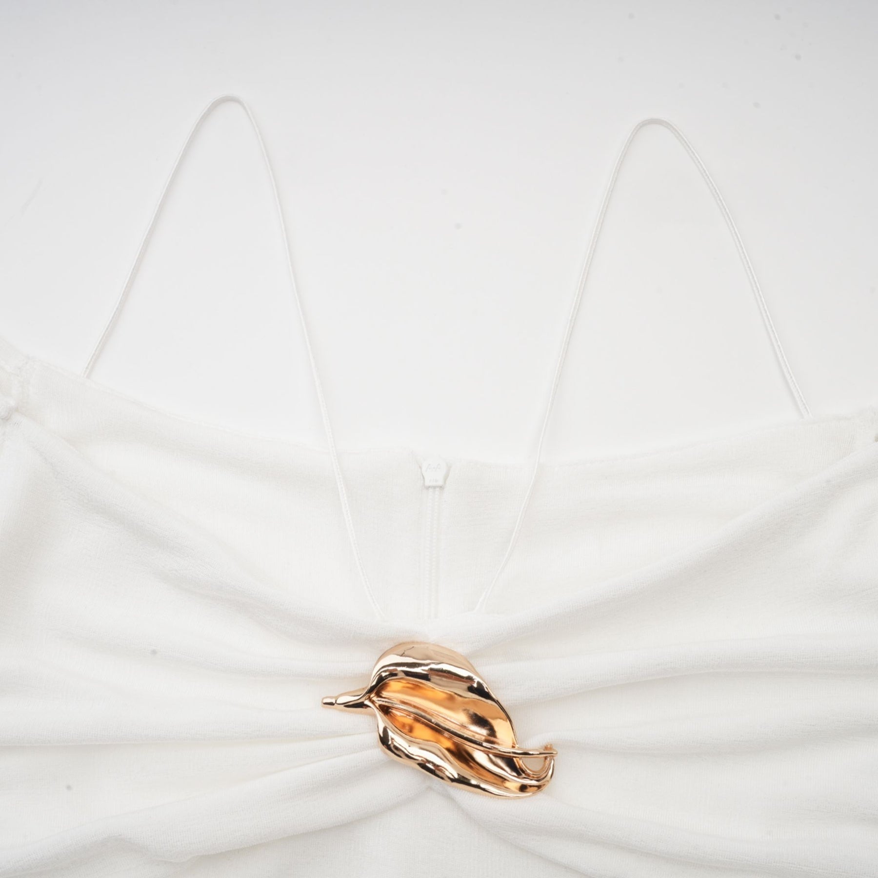 A white offshoulder maxi dress with panelled design featuring a fitted bodice and flowing skirt worn by a model against a plain background