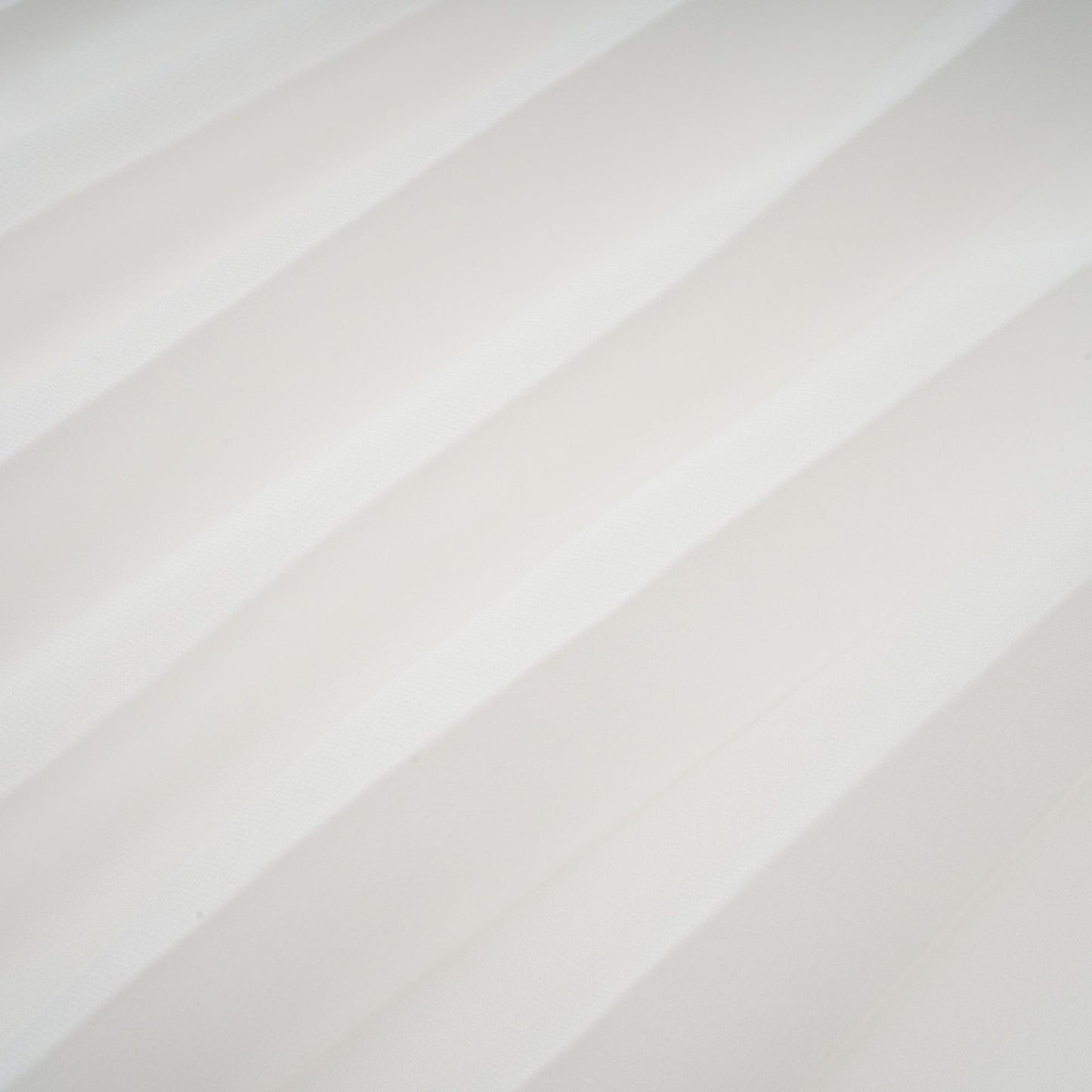 A white offshoulder maxi dress with pleated details and a flowing silhouette worn by a model named Vanessa