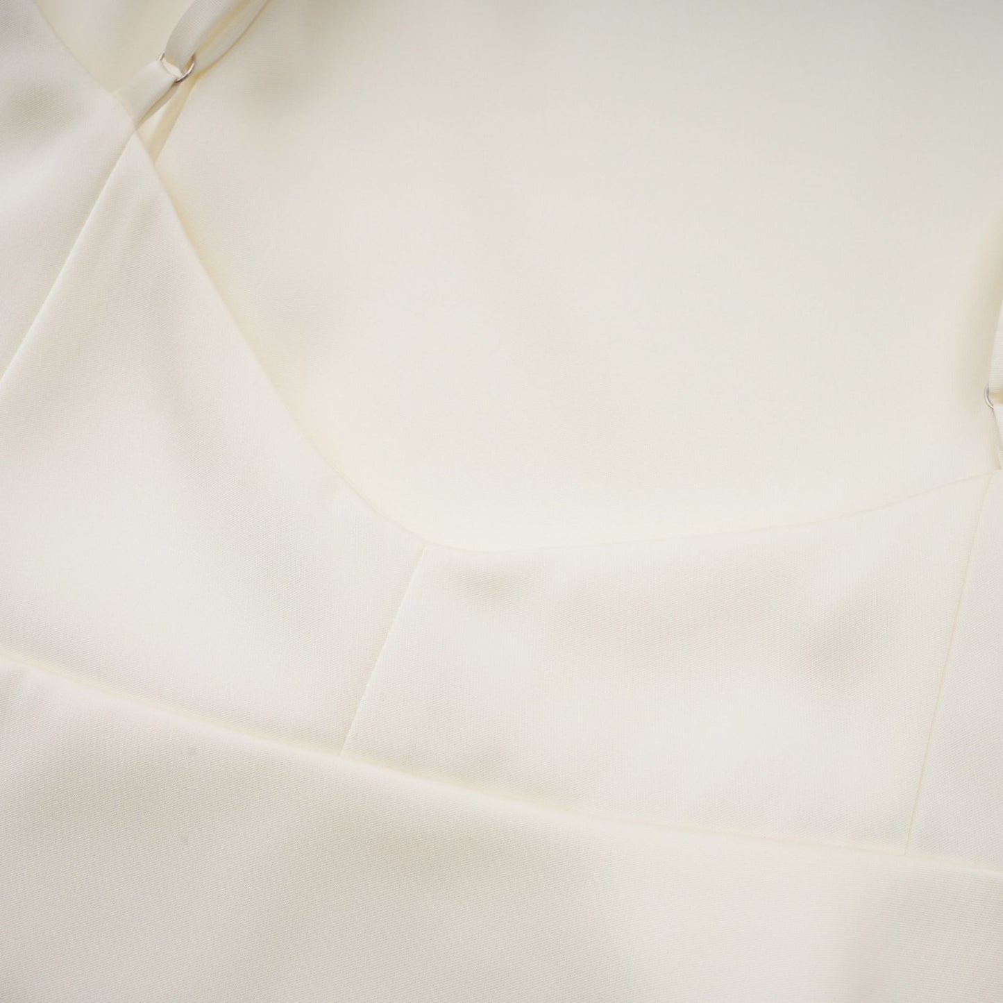 A white satin mini dress with ruffled details and a shawl panel accent The dress has a short length and a feminine silhouette The fabric appears smooth and shiny The shawl panel adds a unique and elegant touch to the overall design